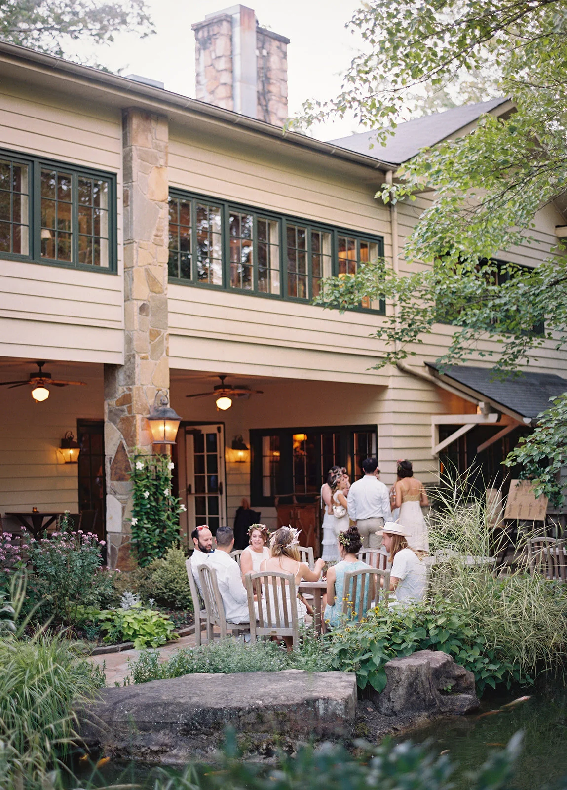 White linen welcome dinner with flower crown for every guest. Wildflower crown booth by Rosemary & Finch, RT Lodge and Nashville luxury wedding florist.