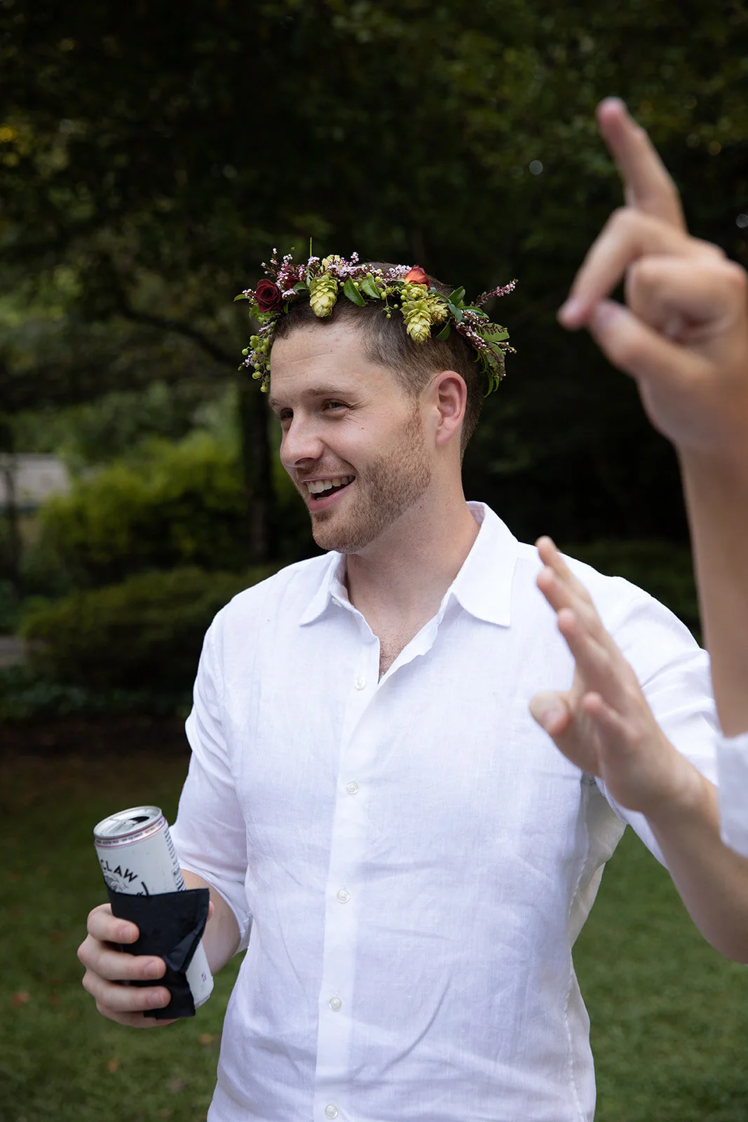 White linen welcome dinner with flower crown for every guest. Wildflower crown booth by Rosemary & Finch, RT Lodge and Nashville luxury wedding florist.