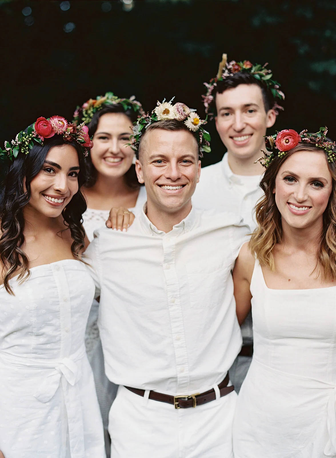 White linen welcome dinner with flower crown for every guest. Wildflower crown booth by Rosemary & Finch, RT Lodge and Nashville luxury wedding florist.