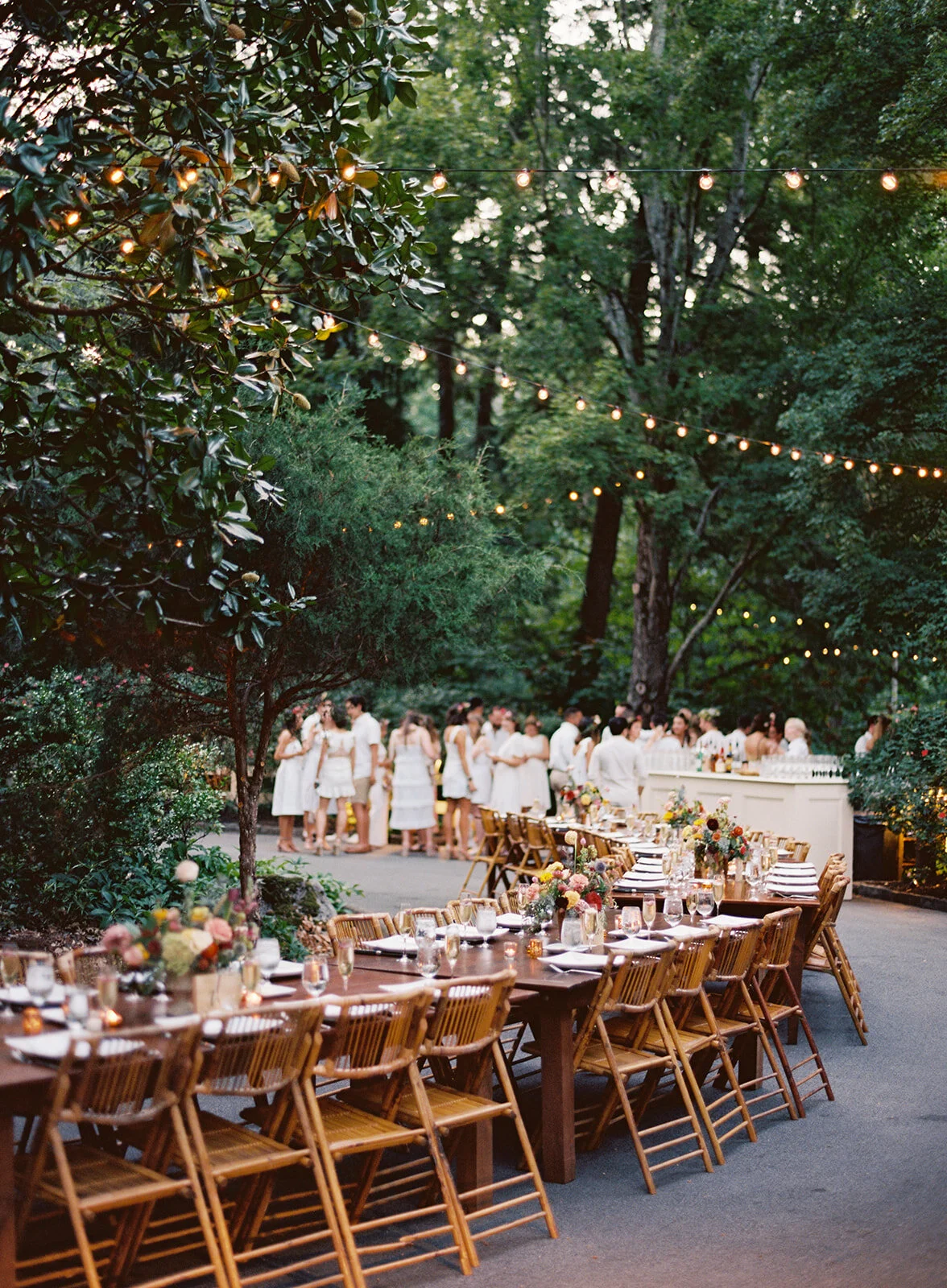 Welcome dinner on the front drive with wildflower centerpieces using ranunculus, chinos, hops, blackberries, persimmons, hops, garden roses, and natural, asymmetrical greenery. RT Lodge and Nashville wedding florist.