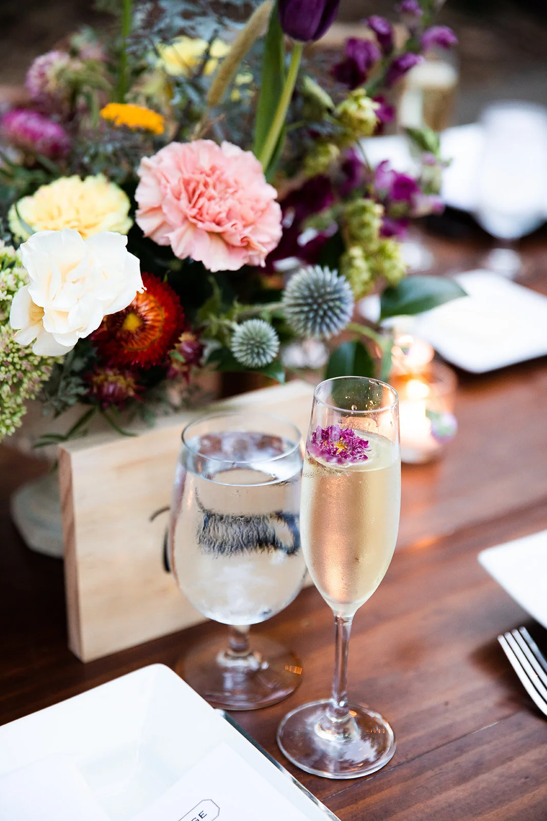 Welcome dinner on the front drive with wildflower centerpieces using ranunculus, chinos, hops, blackberries, persimmons, hops, garden roses, and natural, asymmetrical greenery. RT Lodge and Nashville wedding florist.