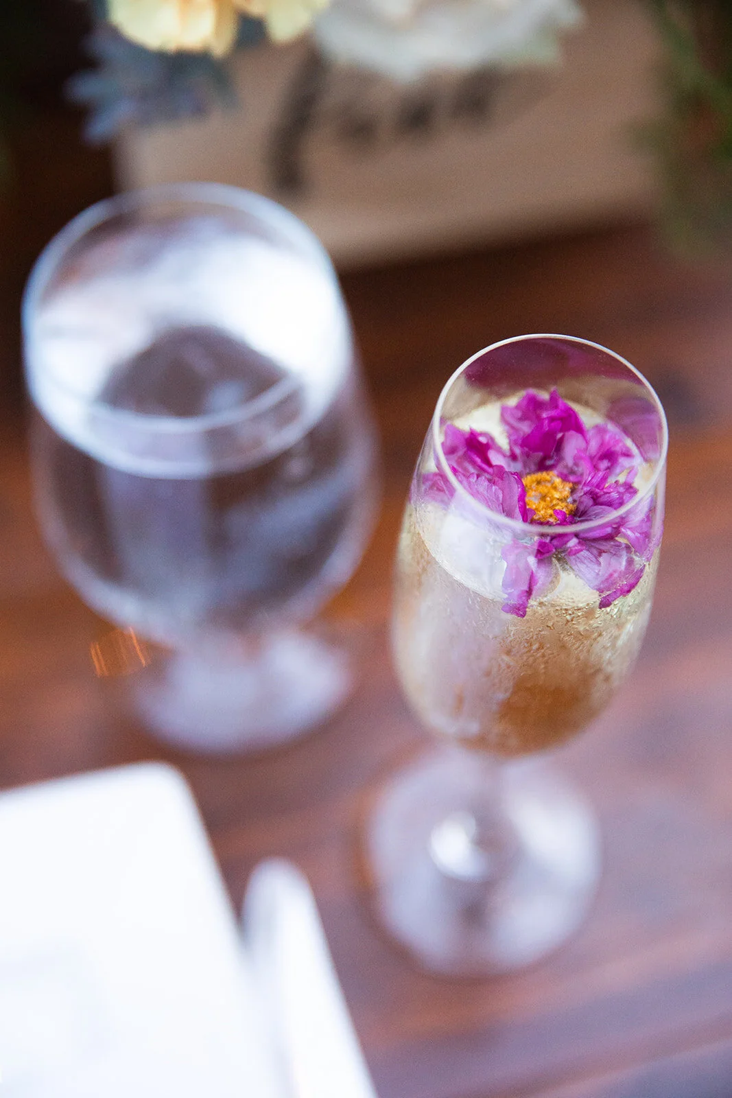 Garden urn wildflower centerpiece with deep red garden roses, dusty pink ranunculus, hops, berries, maroon snapdragon, thistles, golden yellow zinnias, and natural greenery. RT Lodge and Nashville luxury wedding floral designer.