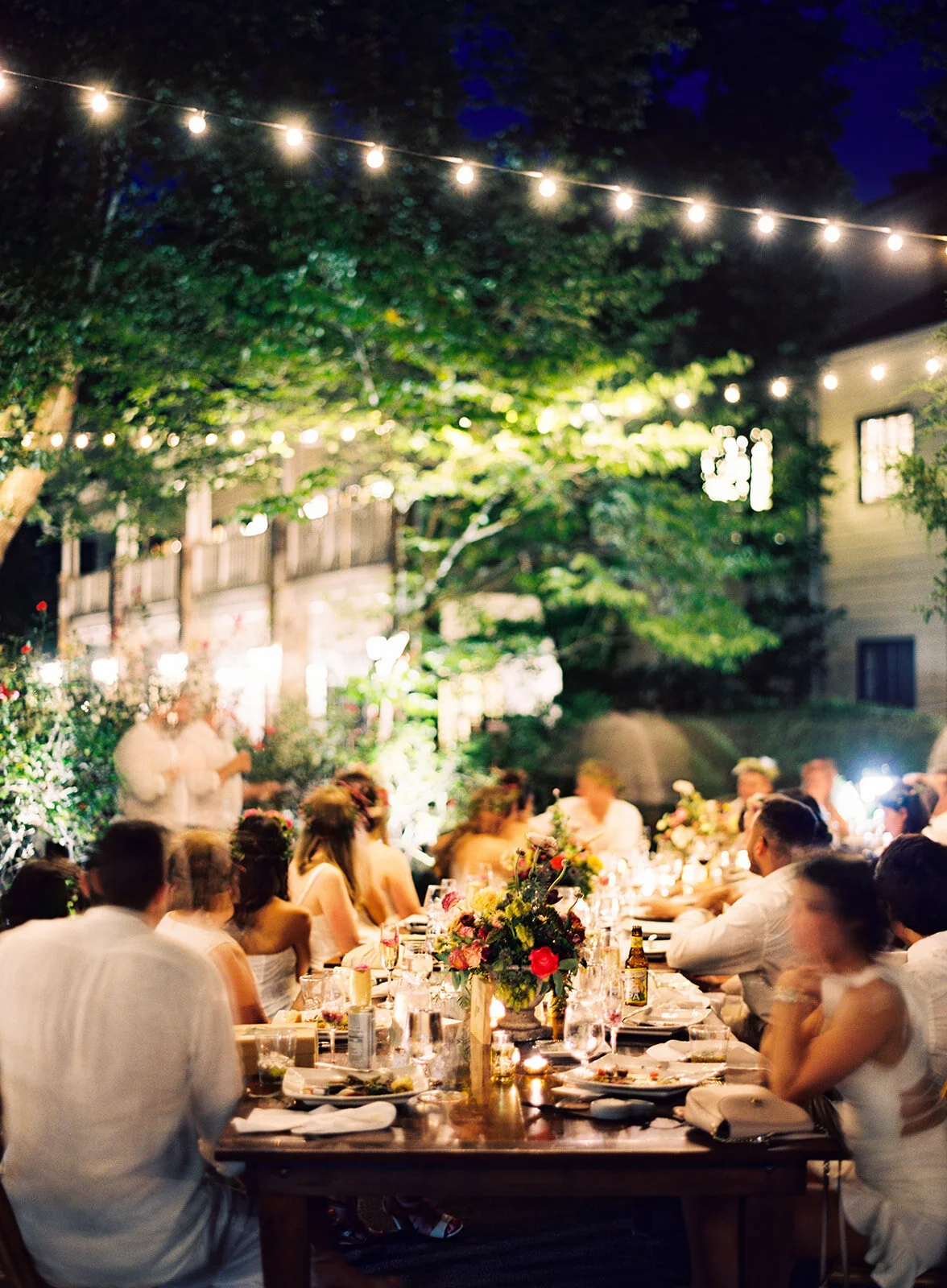 Welcome dinner on the front drive with wildflower centerpieces using ranunculus, chinos, hops, blackberries, persimmons, hops, garden roses, and natural, asymmetrical greenery. RT Lodge and Nashville wedding florist.