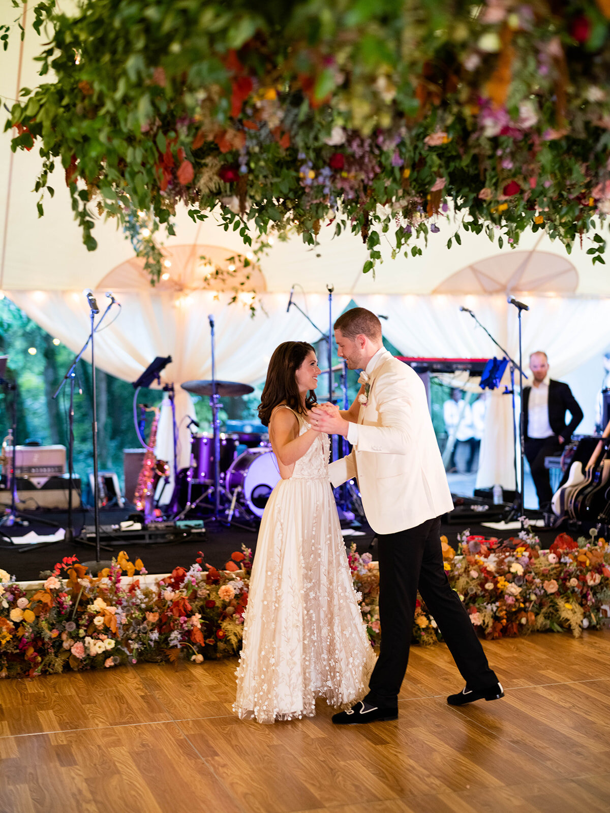 An oversized square hanging flower installation over the dance floor is a great alternative to a floral chandelier! This one has lush smilax vines, hops, copper beech, and bright wildflowers. RT Lodge and Nashville wedding floral designer.