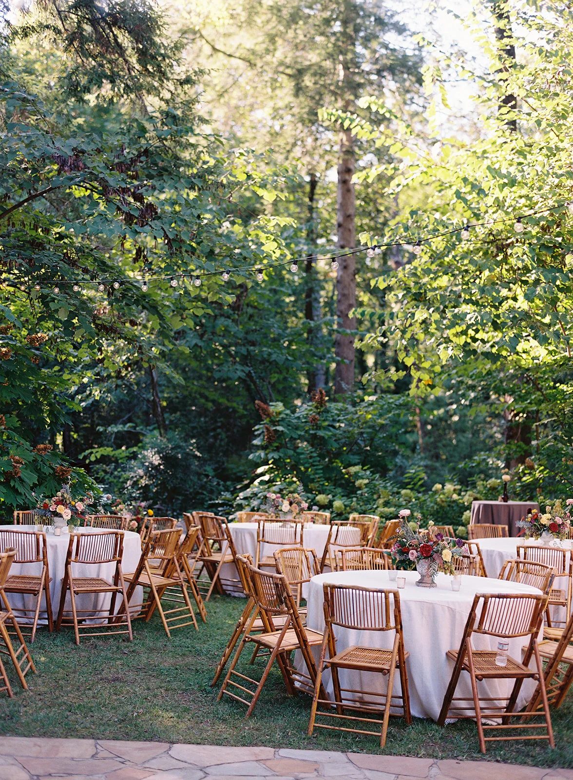 Garden urn wildflower centerpiece with deep red garden roses, dusty pink ranunculus, hops, berries, maroon snapdragon, thistles, golden yellow zinnias, and natural greenery. RT Lodge and Nashville luxury wedding floral designer.