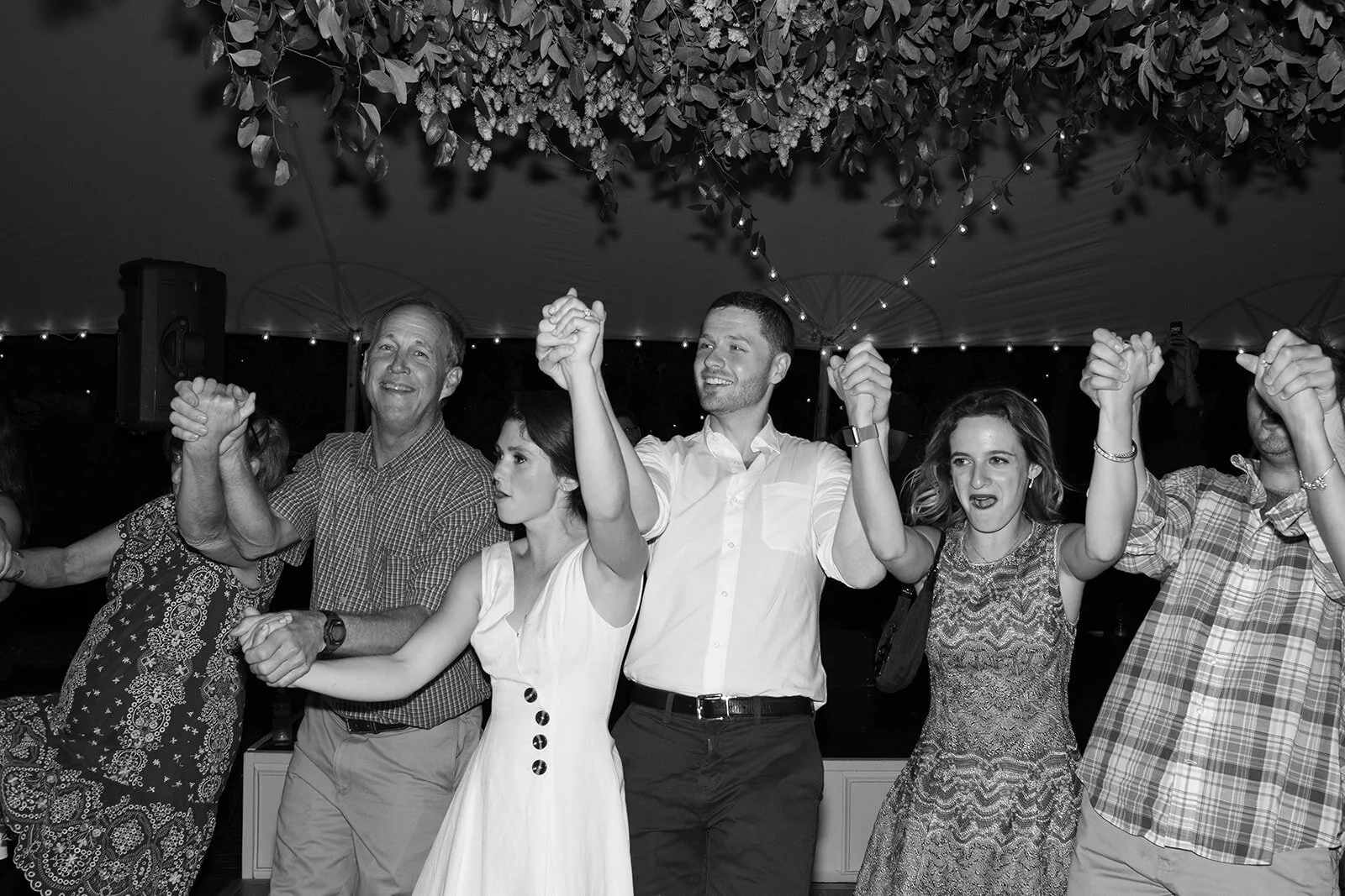 Hanging greenery installation over a square dance for the welcome party. Wedding and event floral design at RT Lodge.
