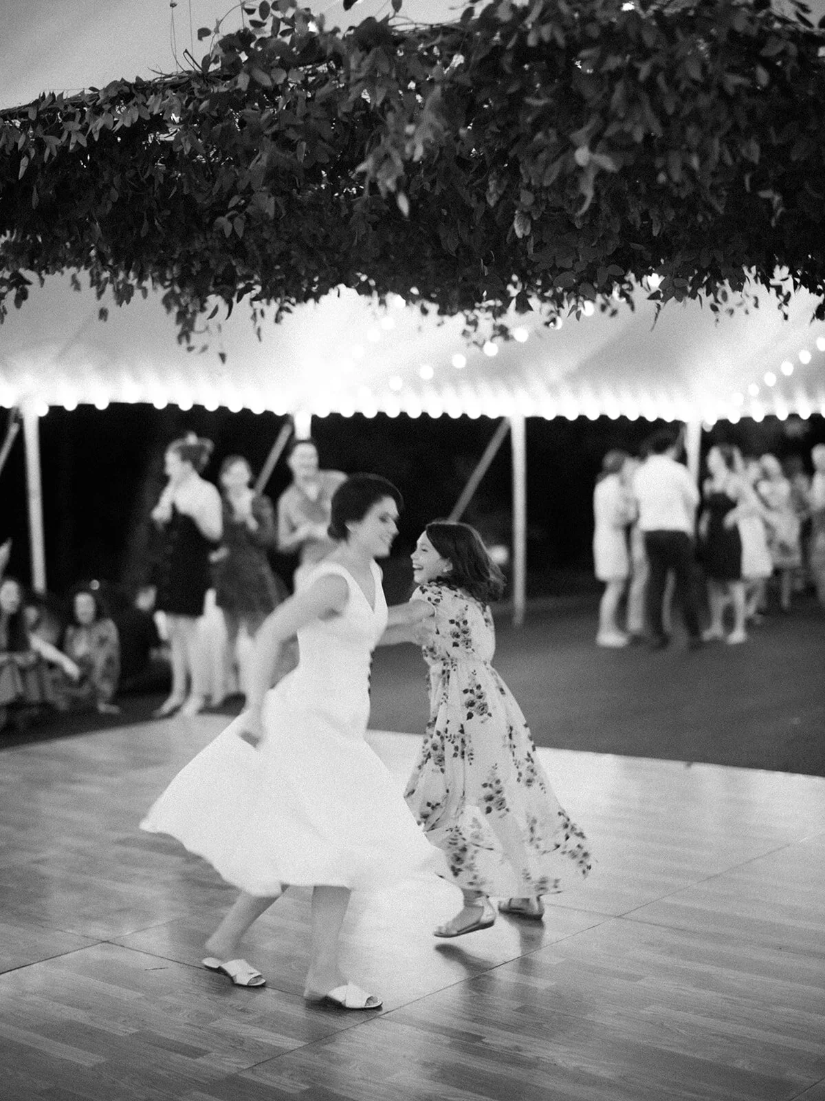 Hanging greenery installation over a square dance for the welcome party. Wedding and event floral design at RT Lodge.