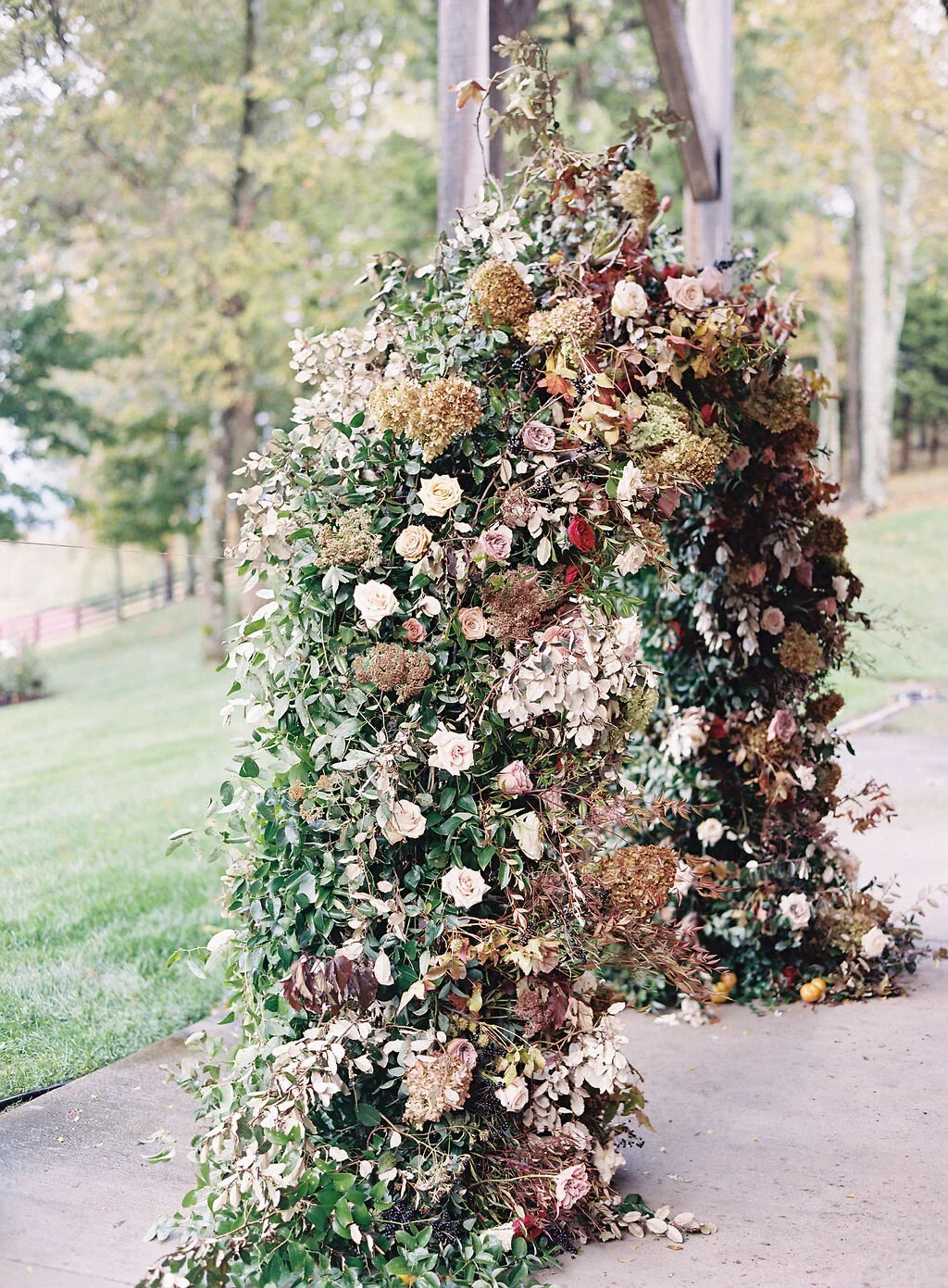 Wild, organic, round floral arch with autumnal color palette and fruit accents. Nashville wedding floral design at Trinity View Farm.