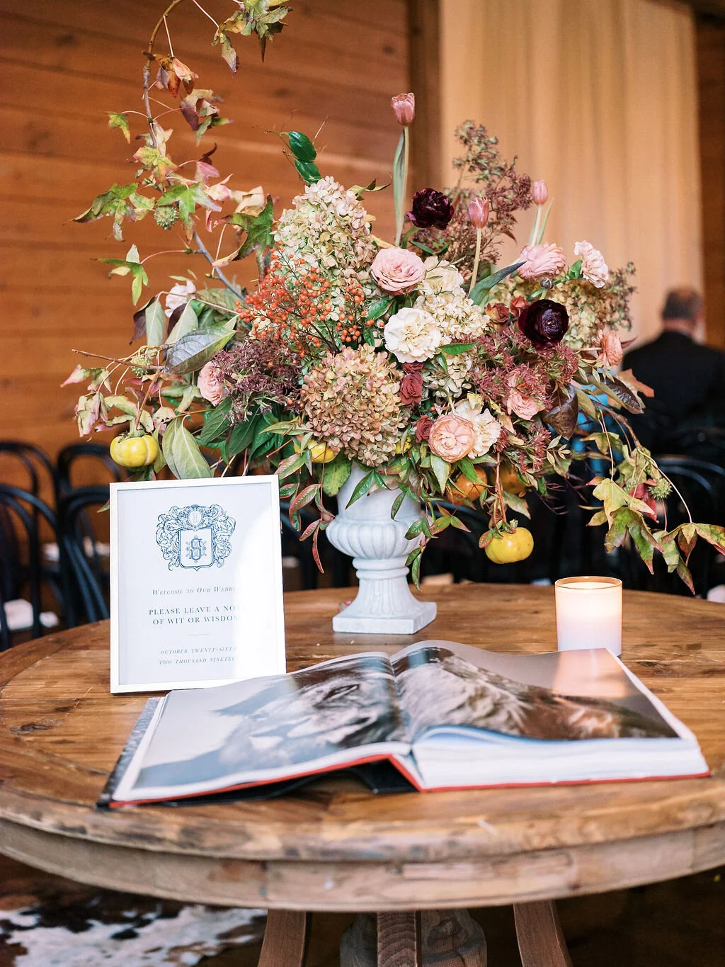 Perfectly muted fall color palette with ivory, dusty rose pink, pops of eggplant, fall leaves, and fruiting persimmon branches. Natural, asymmetrical floral statement arrangement by Nashville florist, Mary Love Richardson of Rosemary & Finch.