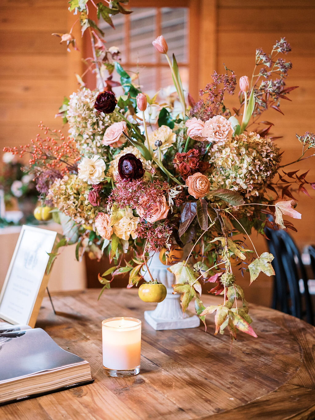 Perfectly muted fall color palette with ivory, dusty rose pink, pops of eggplant, fall leaves, and fruiting persimmon branches. Natural, asymmetrical floral statement arrangement by Nashville florist, Mary Love Richardson of Rosemary & Finch.