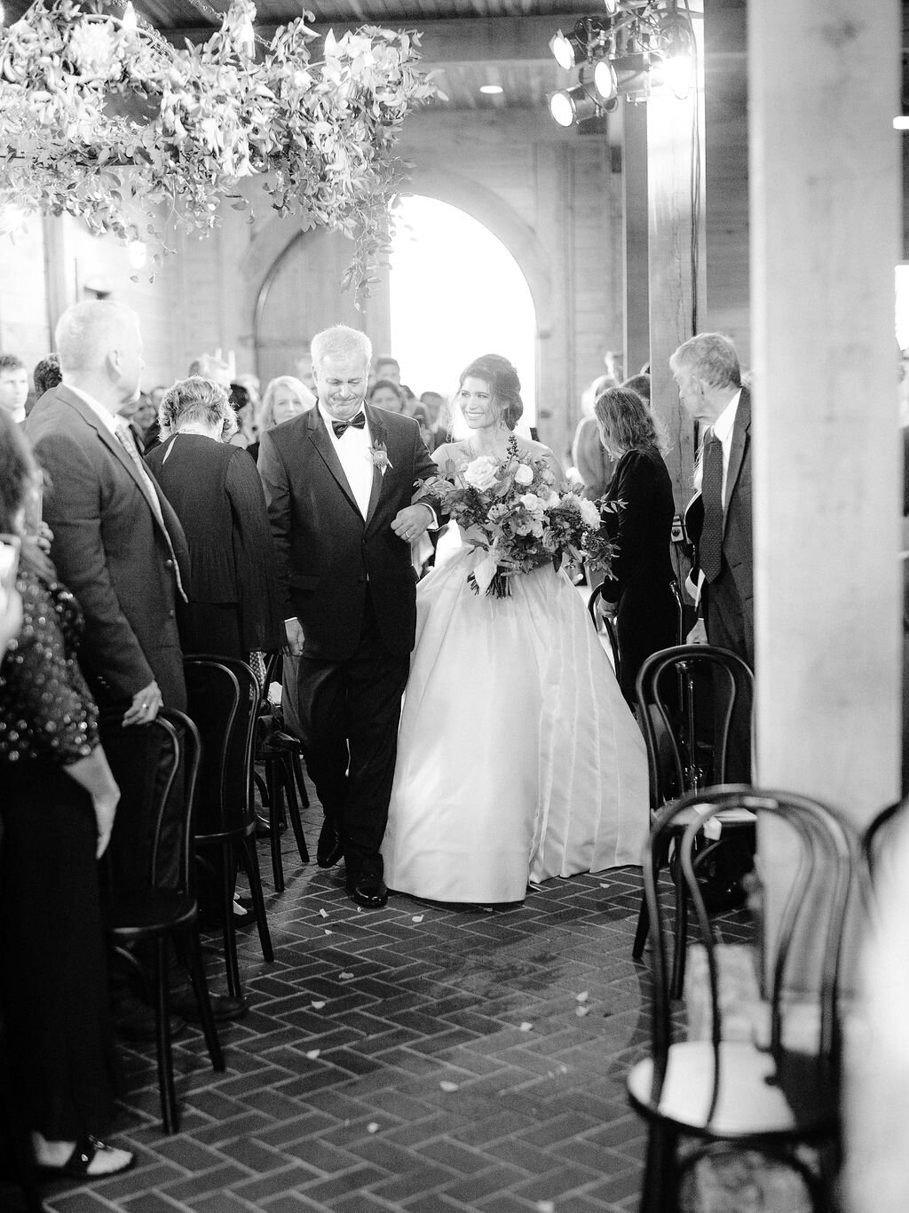 Lush, wild, untamed fall bridal bouquet with a muted autumnal color palette, composed of ligustrum berries, dusty pink ranunculus, tulips, garden roses, fall leaves, begonia leaves, and muted textures. Nashville wedding and corporate event floral de…