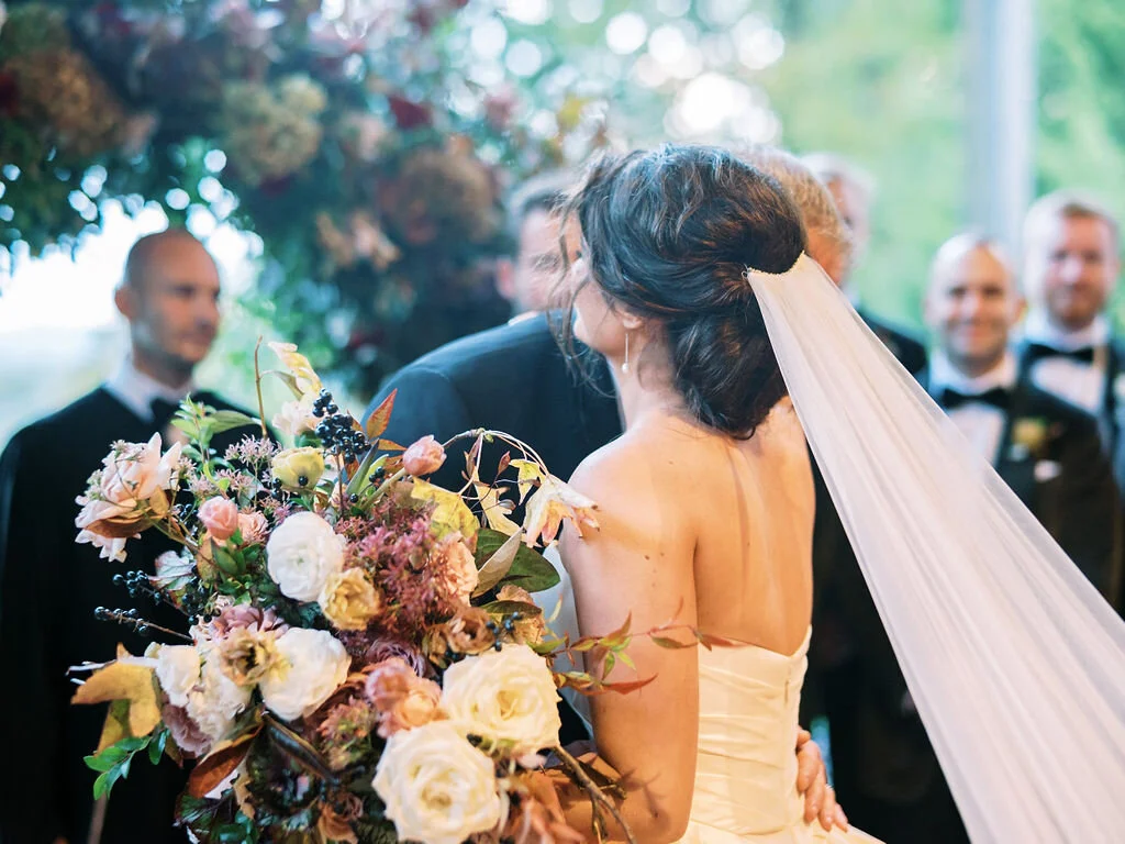Wild, organic, round floral arch with autumnal color palette and fruit accents. Nashville wedding floral design at Trinity View Farm.