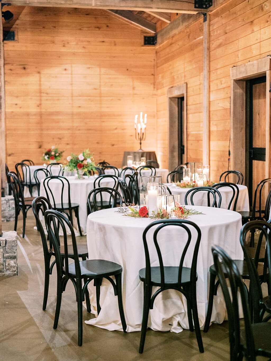 Modern glass lanterns surrounded by lush florals and fruit. Centerpiece for a Trinity View Farm wedding by Nashville florist, Rosemary & Finch.