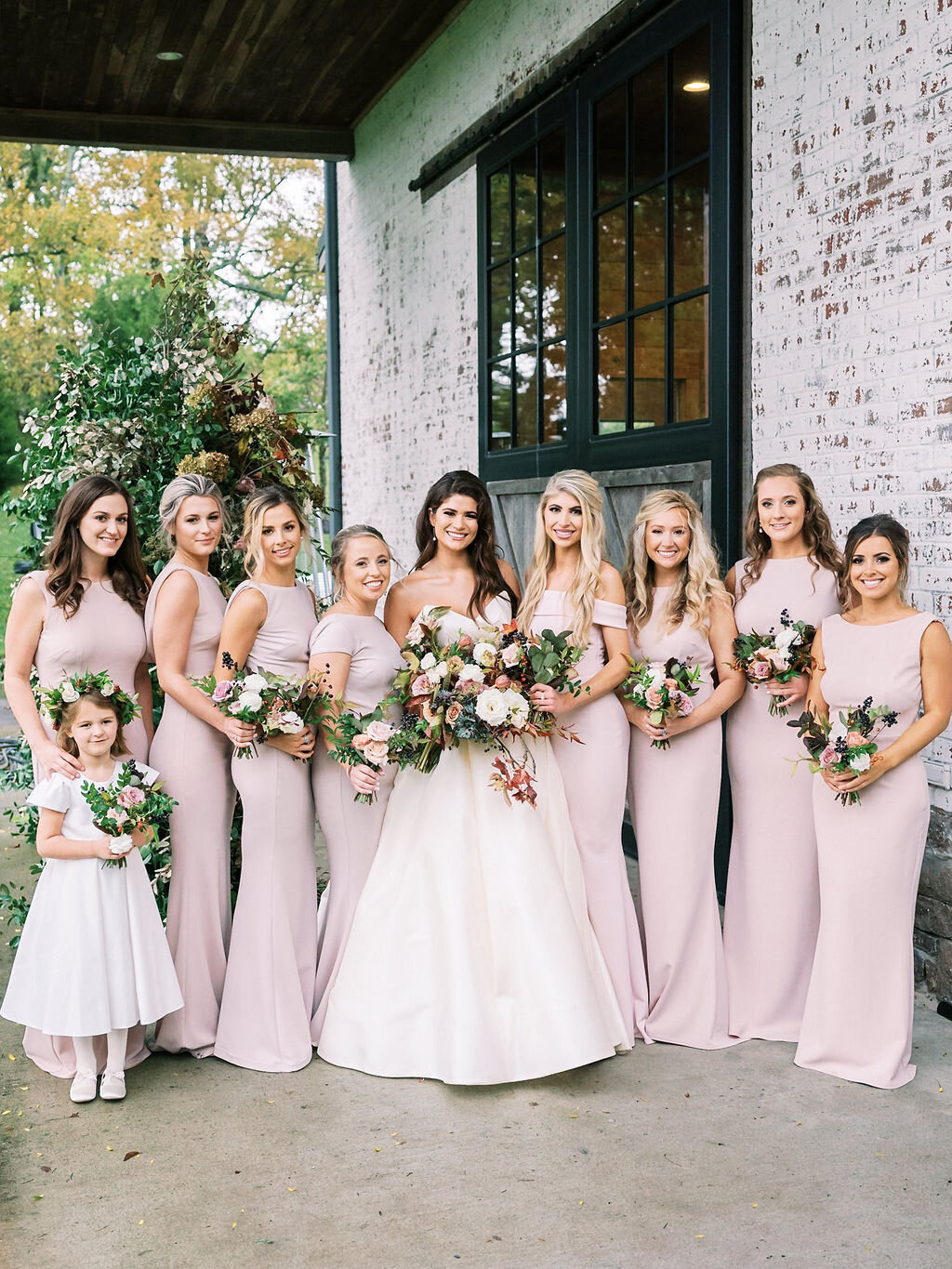 Blush bridesmaid dresses with fall floral bouquets of garden roses, ranunculus, berries, and fall leaves and greenery. Nashville wedding florist at Trinity View Farm.