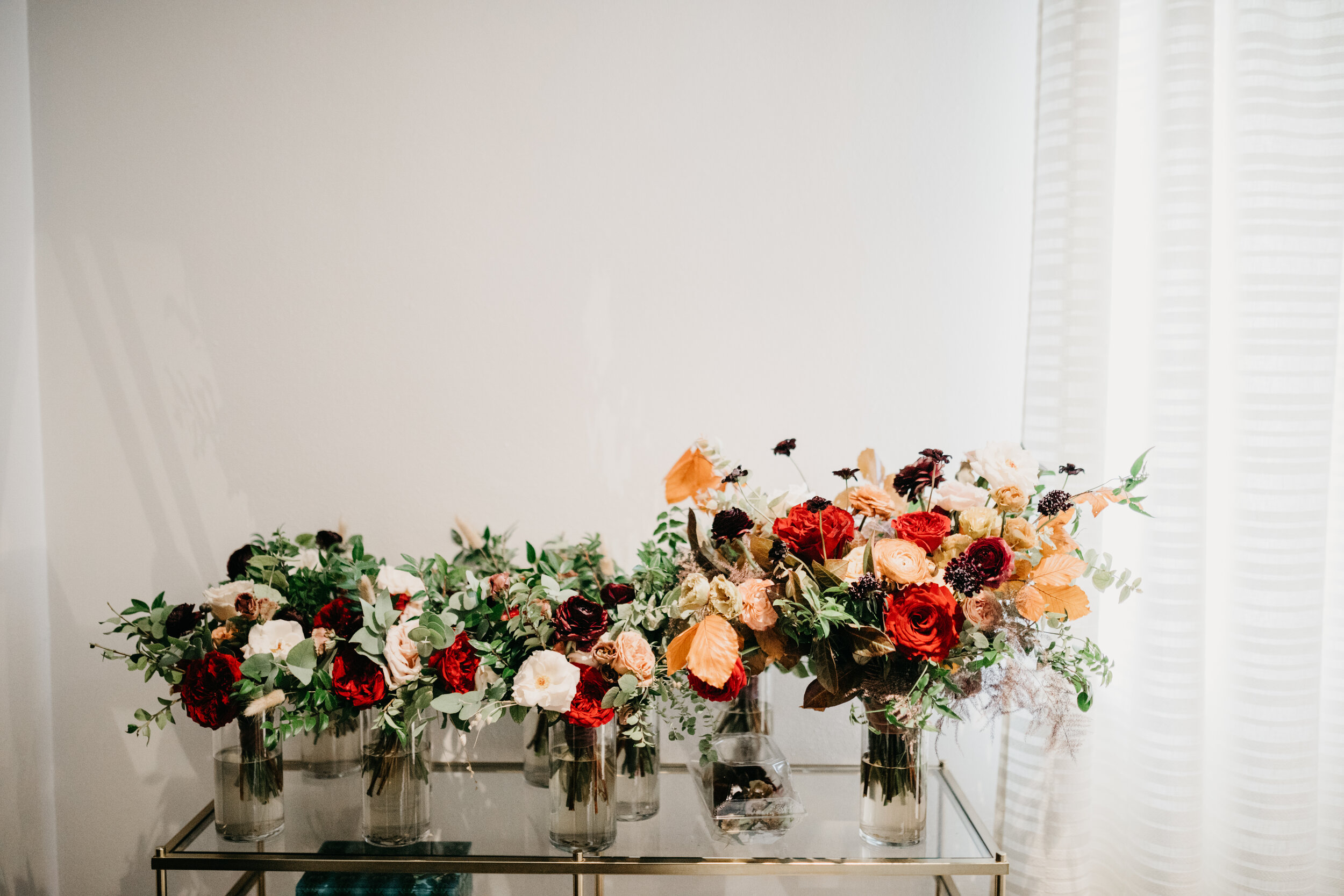 Lush, asymmetrical bridal bouquet with rich fall color palette of deep plum, eggplant, copper, and rusty orange with garden roses, ranunculus, and greenery. Nashville wedding floral designer, Rosemary & Finch, at Clementine.