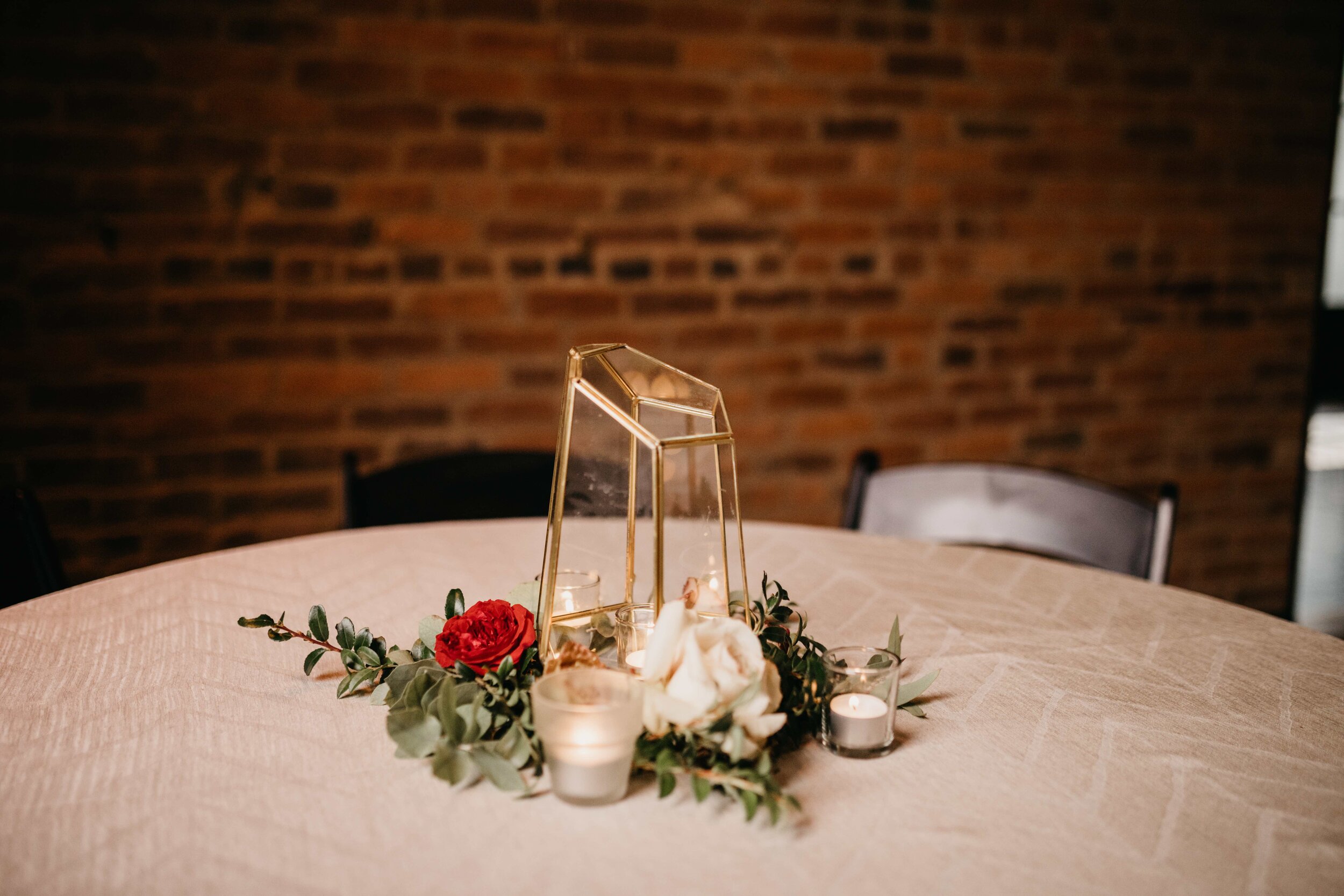 Geometric gold lantern surrounded by autumnal flowers and greenery. Nashville wedding floral design by Rosemary & Finch.