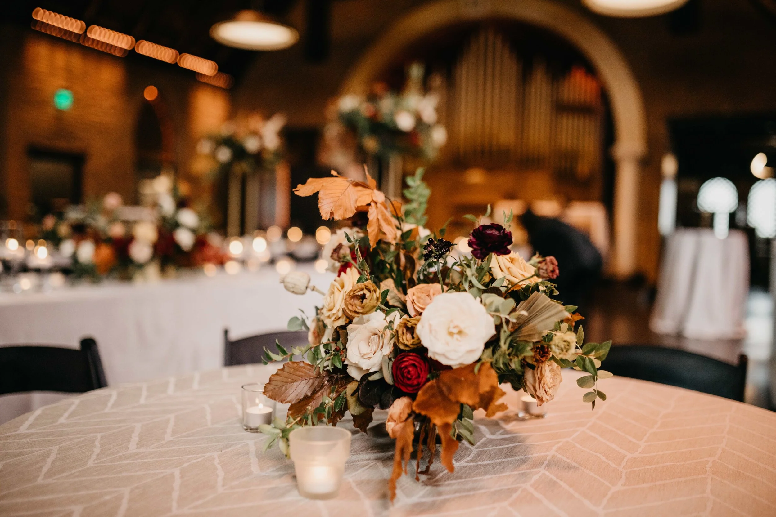Low gold metal vessel for autumnal, textured floral centerpiece with greenery, garden roses, ranunculus, and fall foliage. Nashville, TN and Southeastern US luxury floral designer, Rosemary & Finch.