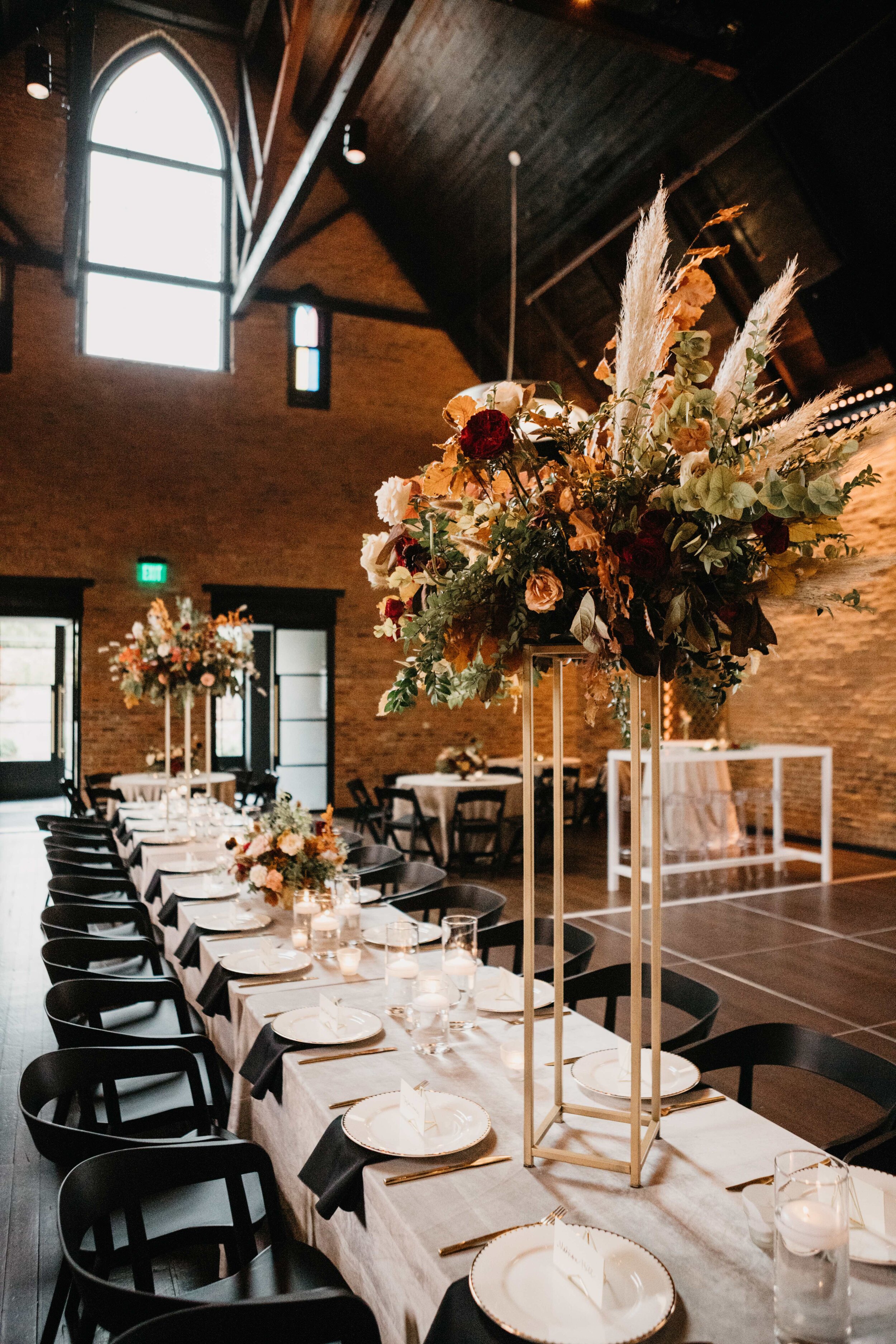 Modern gold stand with lush, asymmetrical floral arrangements using copper beech, pampas grass, garden roses, dahlias, and ranunculus in shades on rusty orange, burgundy, and muted earth tones. Nashville wedding floral design at Clementine.