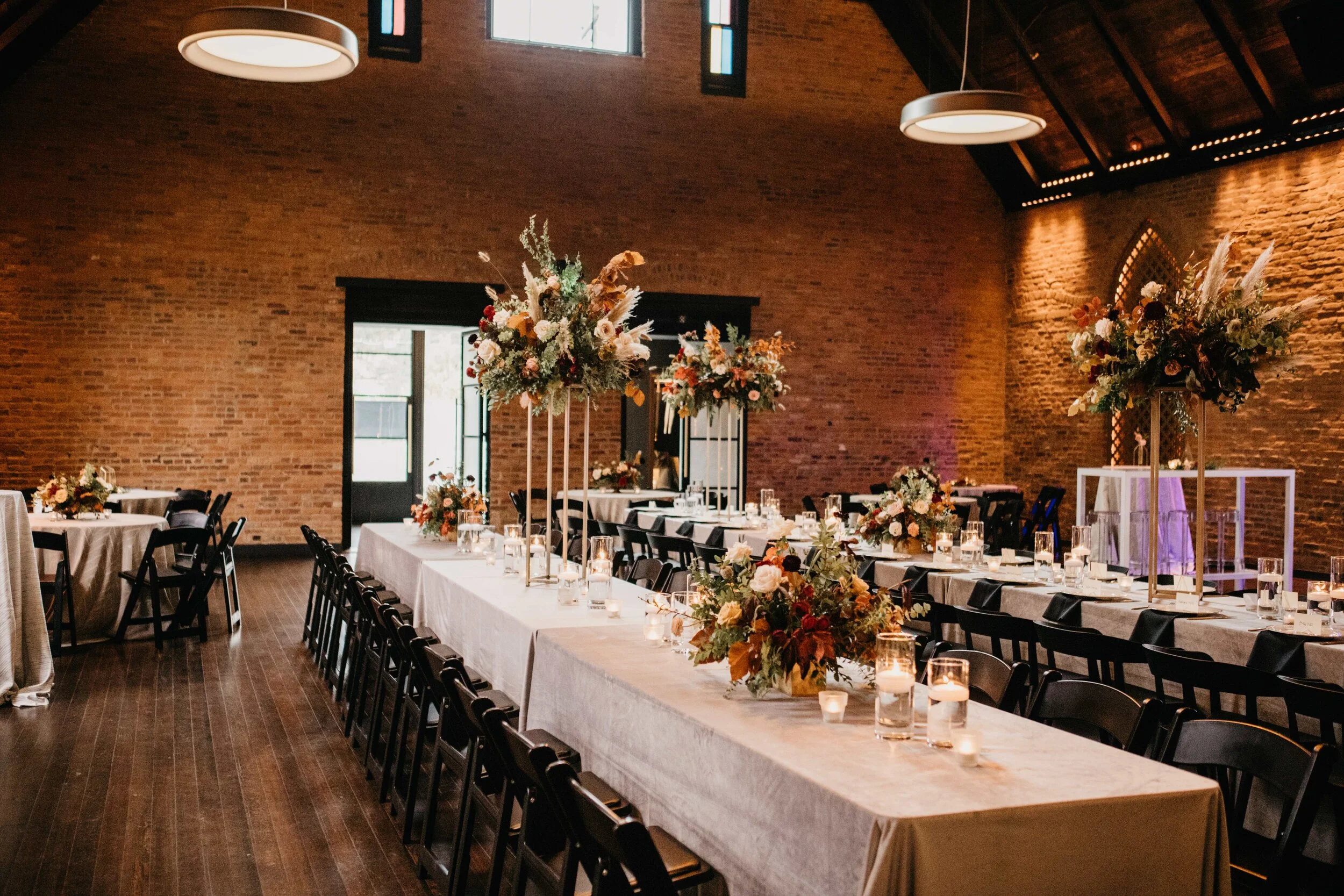 Modern gold stand with lush, asymmetrical floral arrangements using copper beech, pampas grass, garden roses, dahlias, and ranunculus in shades on rusty orange, burgundy, and muted earth tones. Nashville wedding floral design at Clementine.