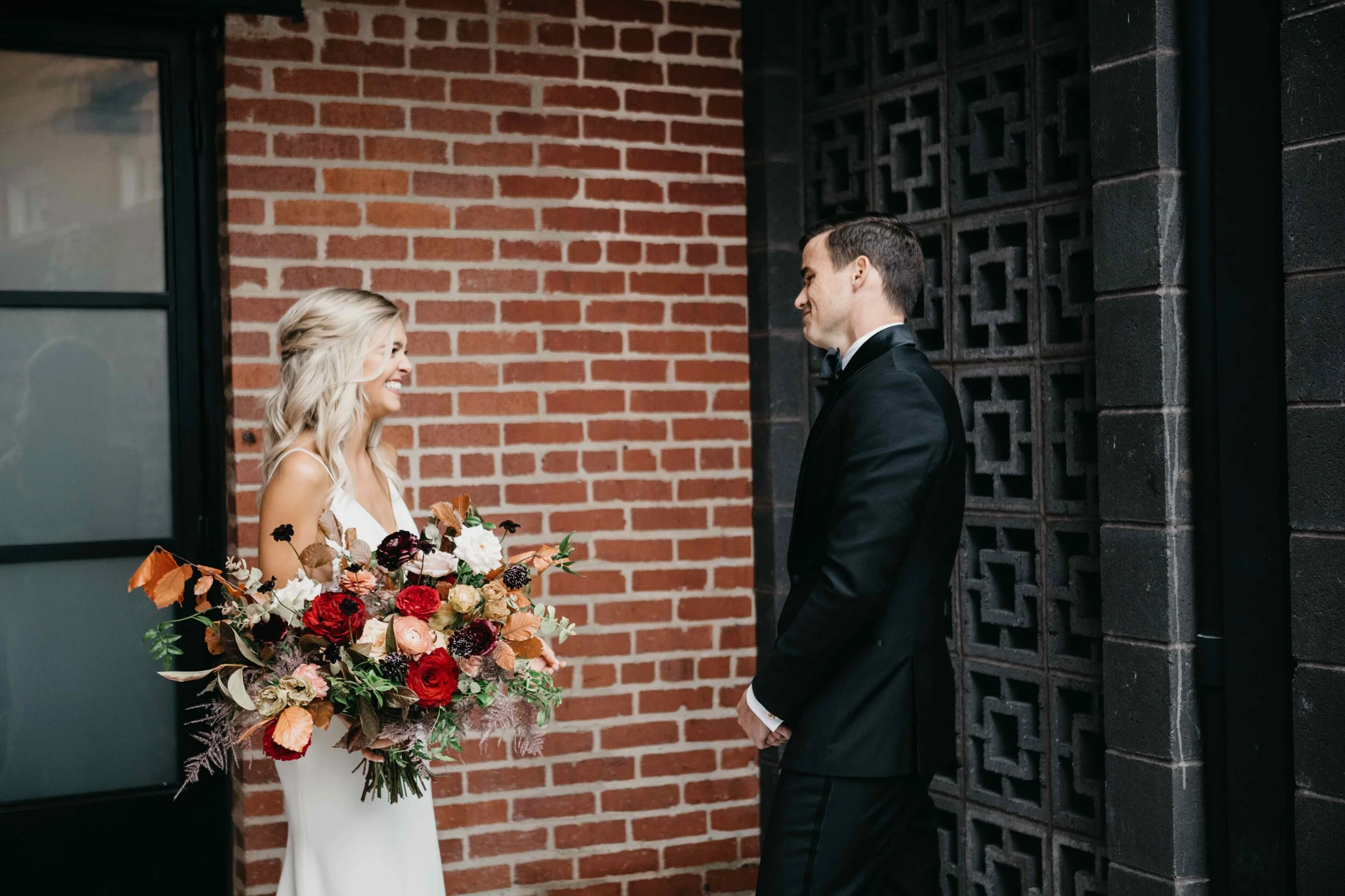 Garden inspired organic bridal bouquet in rich fall color palette using deep red garden roses, eggplant ranunculus, chocolate cosmos, copper beech, dusty rose ranunculus, and natural greenery. Luxury wedding florist in Nashville, TN.