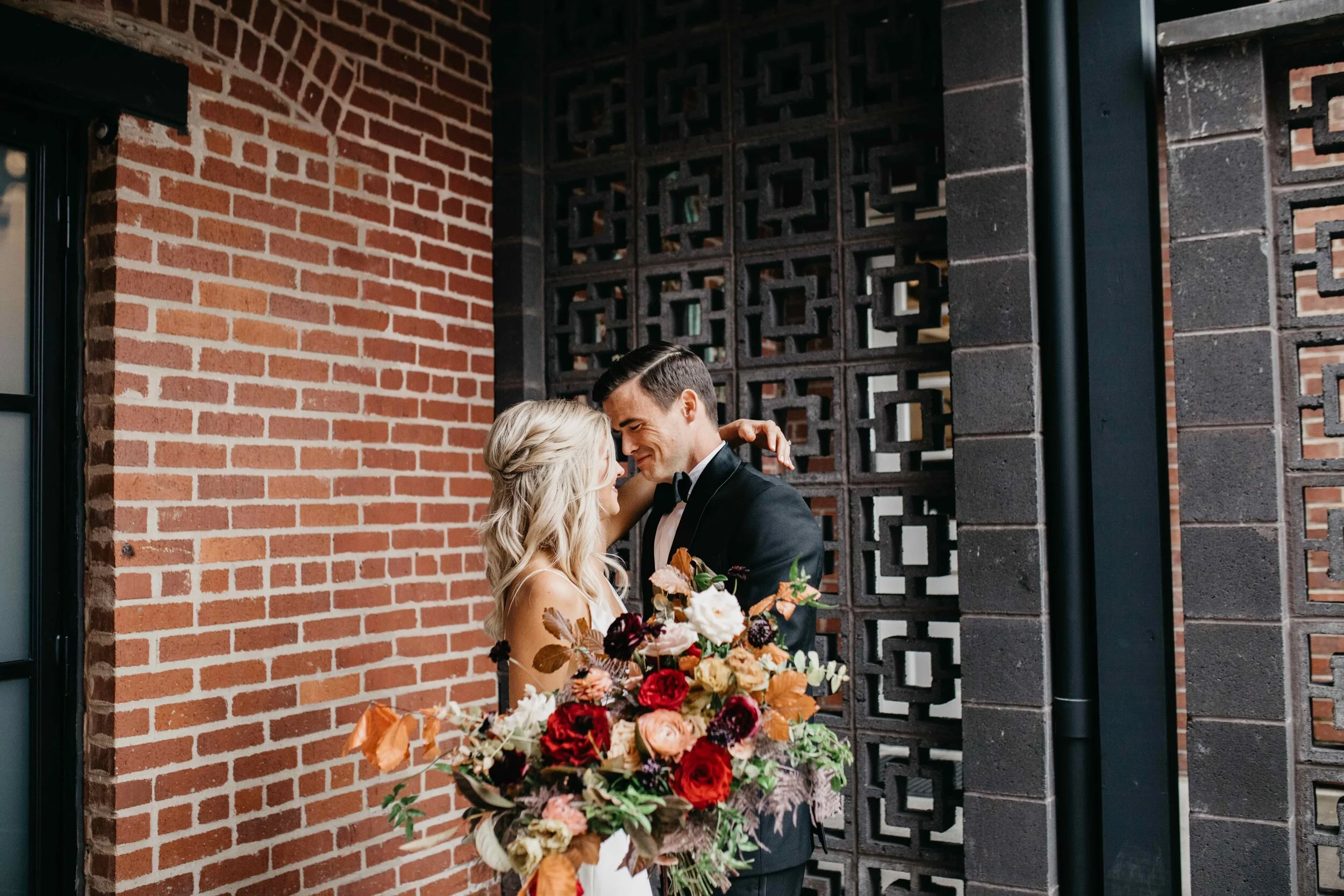 Garden inspired organic bridal bouquet in rich fall color palette using deep red garden roses, eggplant ranunculus, chocolate cosmos, copper beech, dusty rose ranunculus, and natural greenery. Luxury wedding florist in Nashville, TN.