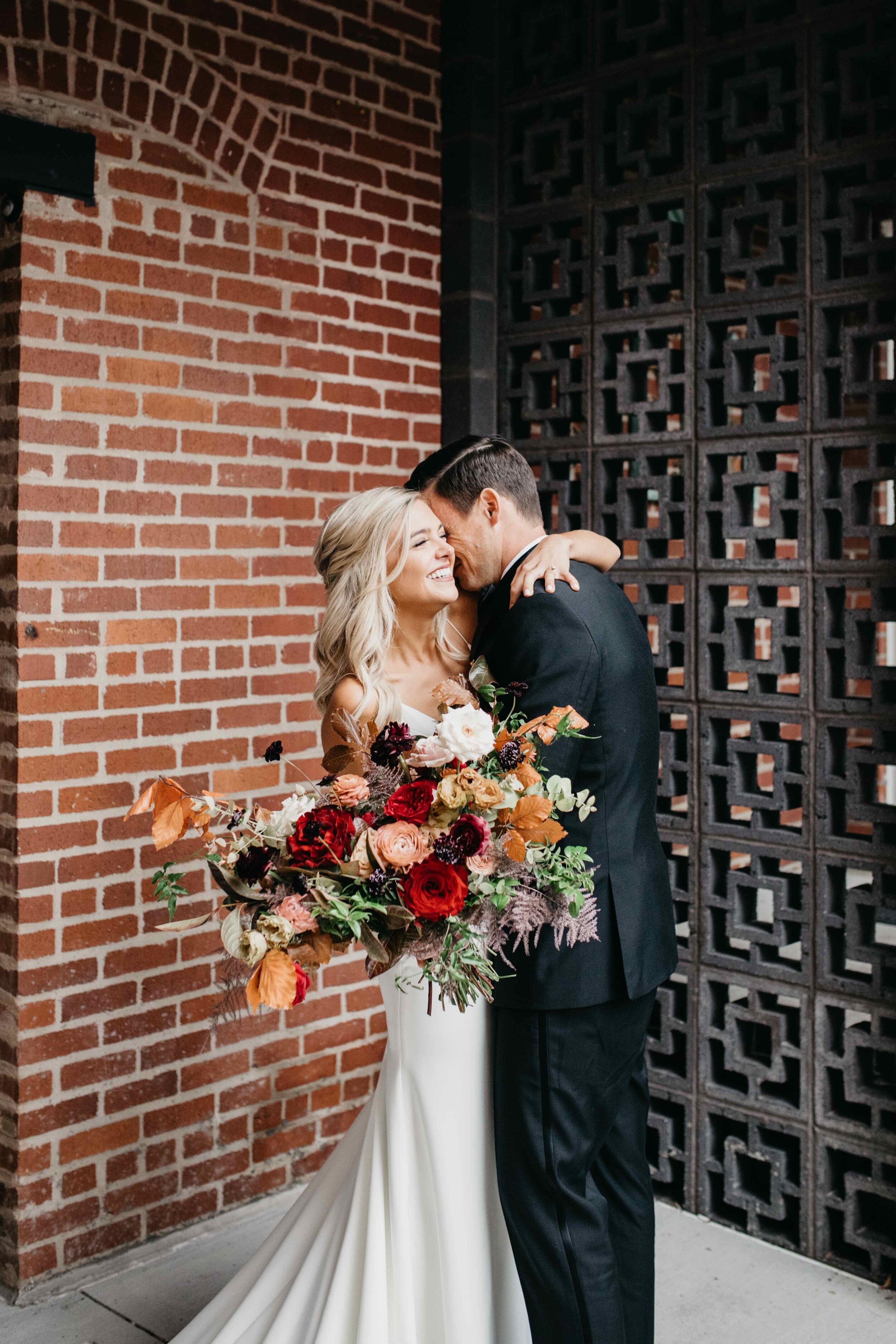 Garden inspired organic bridal bouquet in rich fall color palette using deep red garden roses, eggplant ranunculus, chocolate cosmos, copper beech, dusty rose ranunculus, and natural greenery. Luxury wedding florist in Nashville, TN.