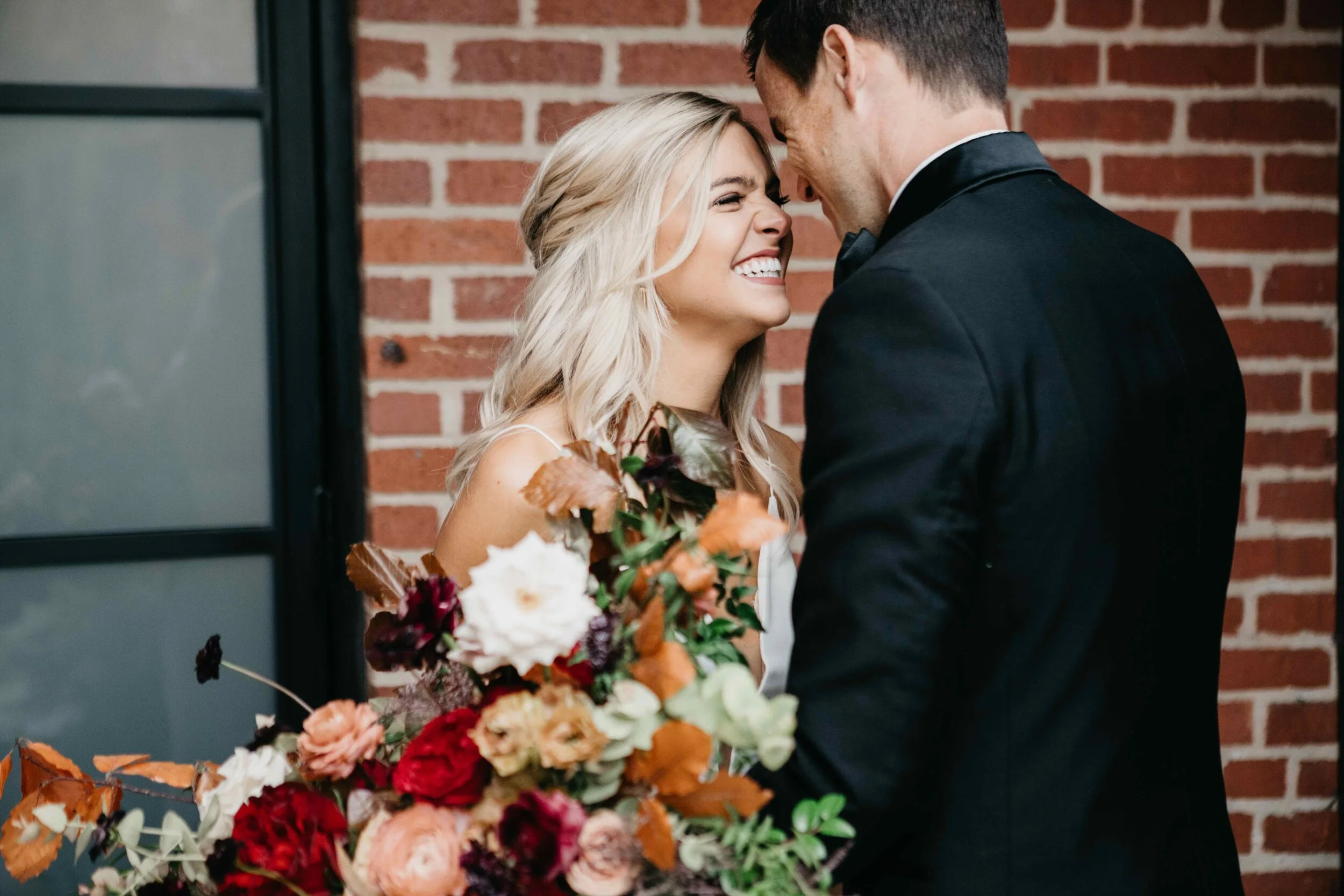 Garden inspired organic bridal bouquet in rich fall color palette using deep red garden roses, eggplant ranunculus, chocolate cosmos, copper beech, dusty rose ranunculus, and natural greenery. Luxury wedding florist in Nashville, TN.