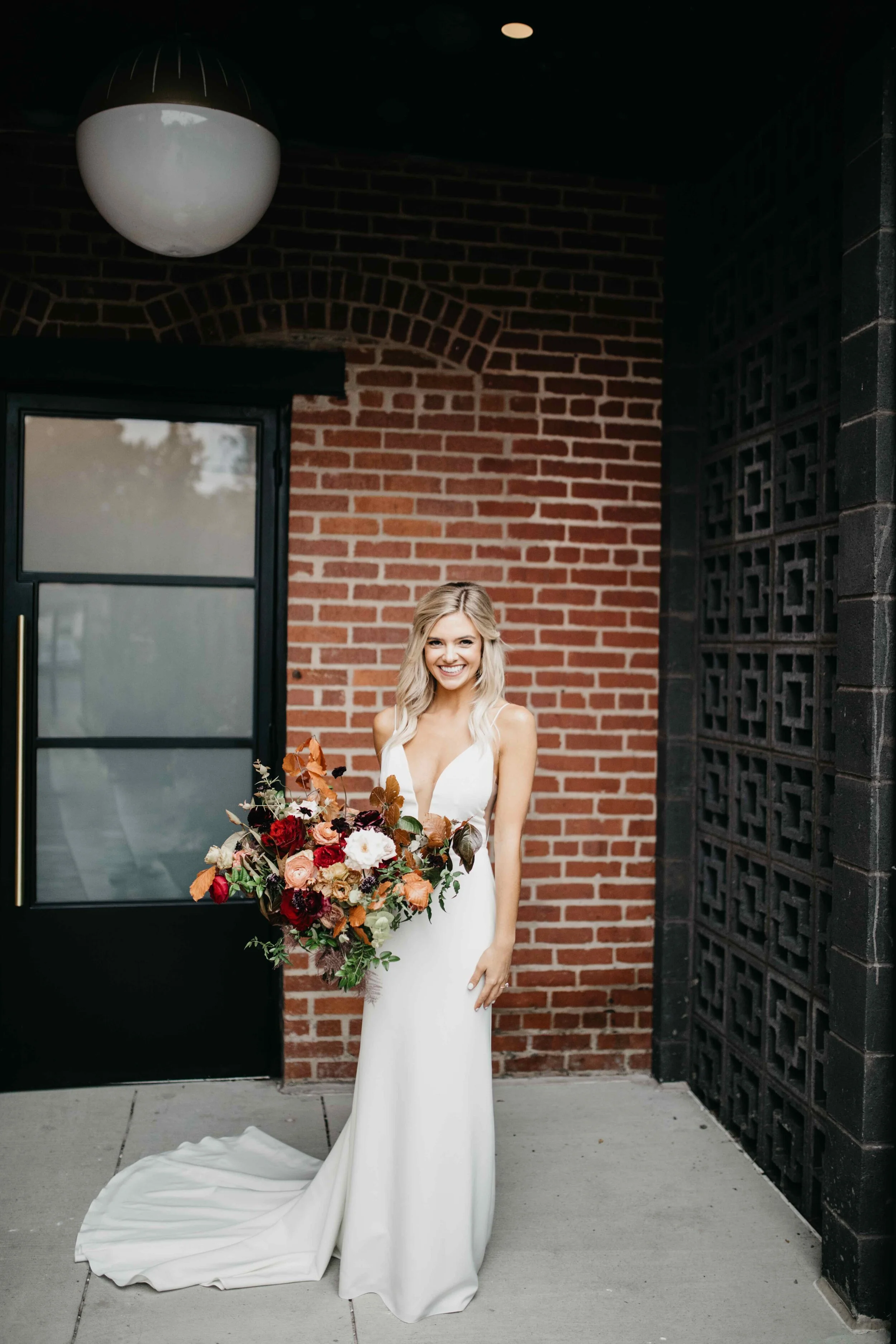 Garden inspired organic bridal bouquet in rich fall color palette using deep red garden roses, eggplant ranunculus, chocolate cosmos, copper beech, dusty rose ranunculus, and natural greenery. Luxury wedding florist in Nashville, TN.