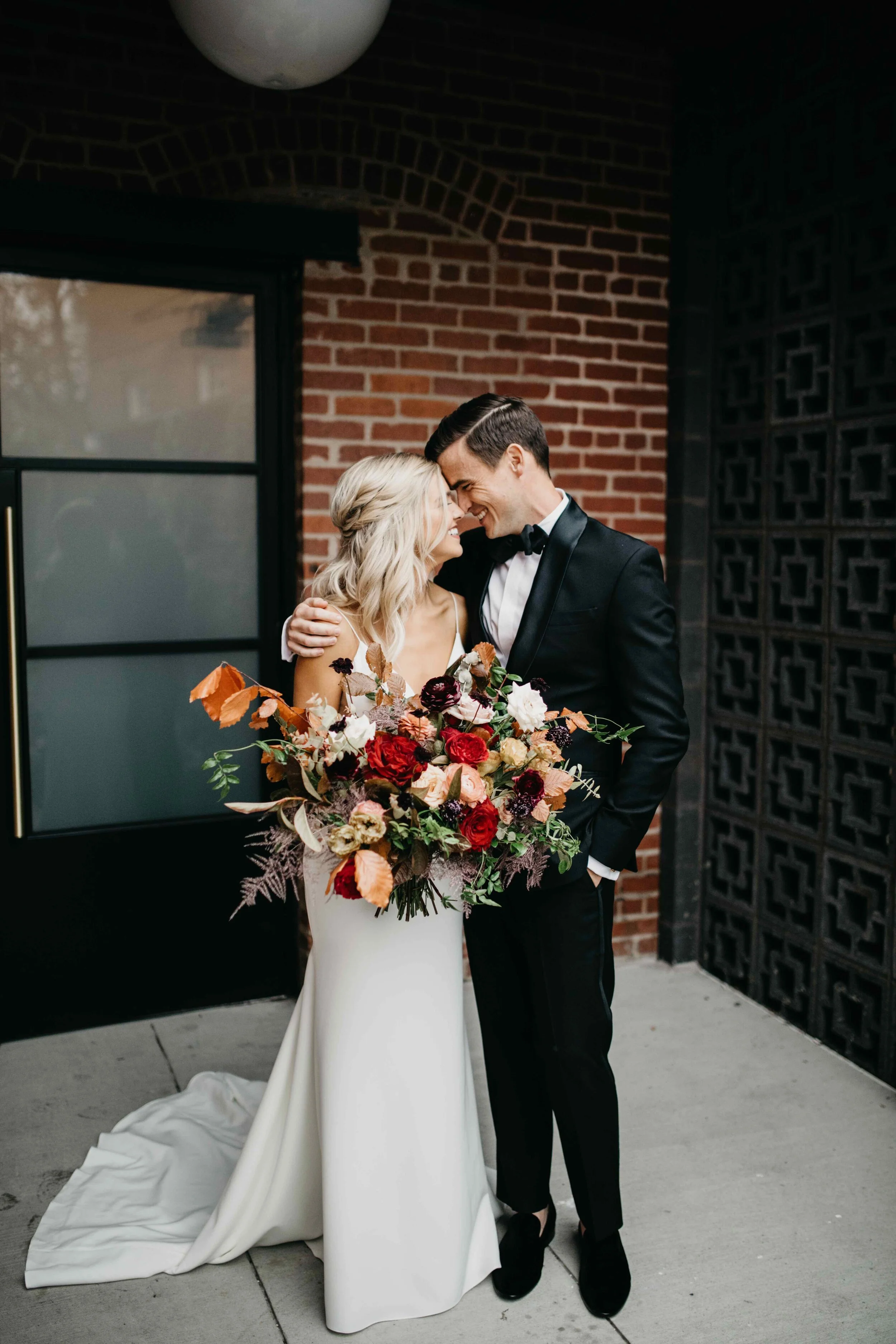 Garden inspired organic bridal bouquet in rich fall color palette using deep red garden roses, eggplant ranunculus, chocolate cosmos, copper beech, dusty rose ranunculus, and natural greenery. Luxury wedding florist in Nashville, TN.