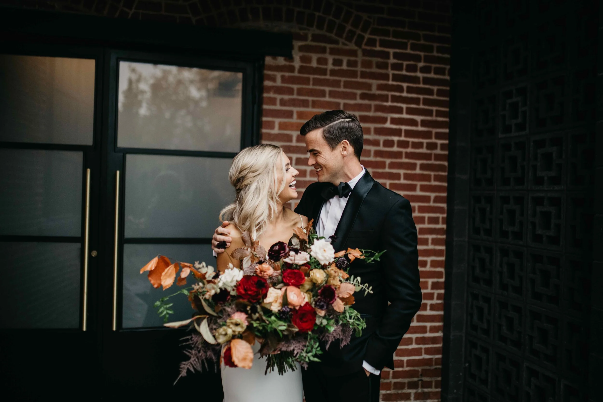 Garden inspired organic bridal bouquet in rich fall color palette using deep red garden roses, eggplant ranunculus, chocolate cosmos, copper beech, dusty rose ranunculus, and natural greenery. Luxury wedding florist in Nashville, TN.