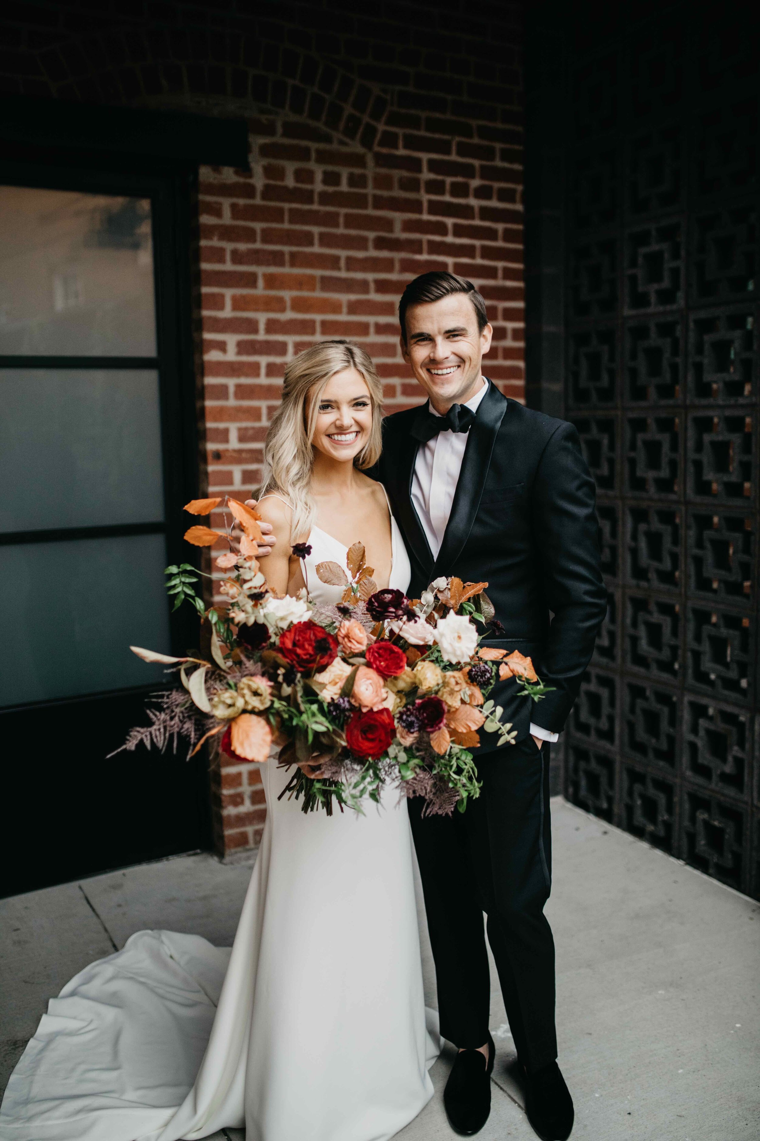 Garden inspired organic bridal bouquet in rich fall color palette using deep red garden roses, eggplant ranunculus, chocolate cosmos, copper beech, dusty rose ranunculus, and natural greenery. Luxury wedding florist in Nashville, TN.