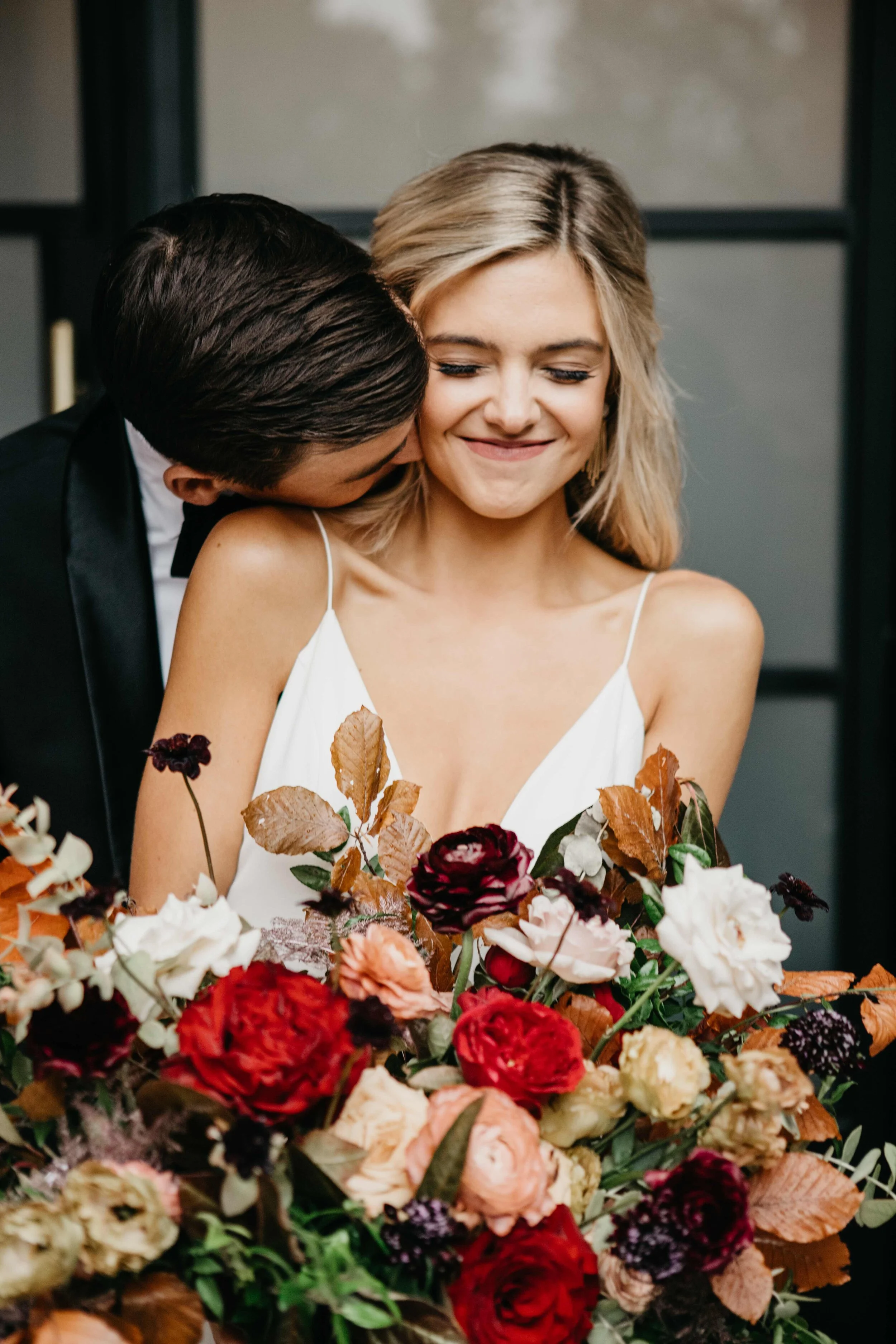 Garden inspired organic bridal bouquet in rich fall color palette using deep red garden roses, eggplant ranunculus, chocolate cosmos, copper beech, dusty rose ranunculus, and natural greenery. Luxury wedding florist in Nashville, TN.