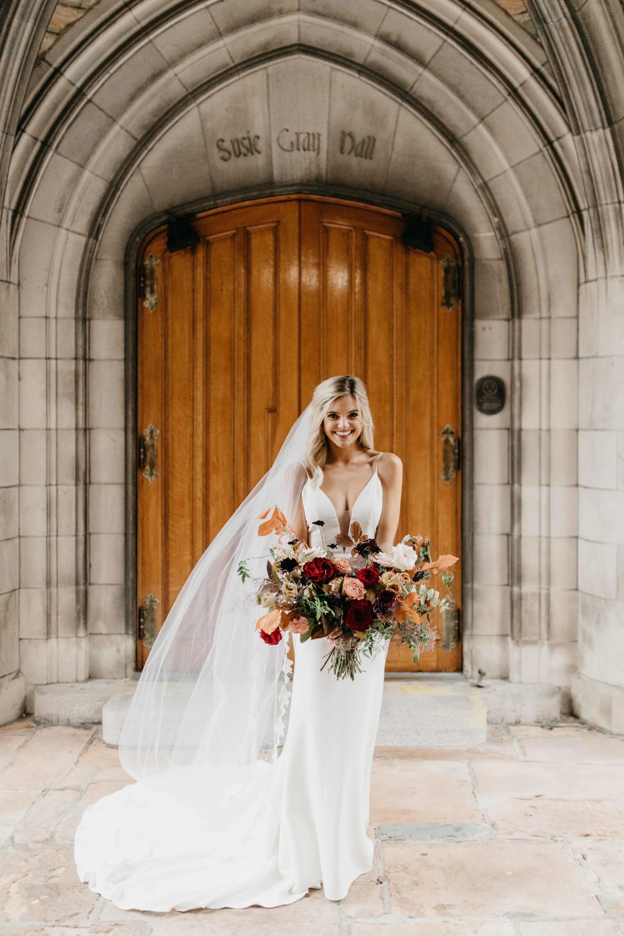 Lush, asymmetrical bridal bouquet with rich fall color palette of deep plum, eggplant, copper, and rusty orange with garden roses, ranunculus, and greenery. Nashville wedding floral designer, Rosemary & Finch, at Clementine.