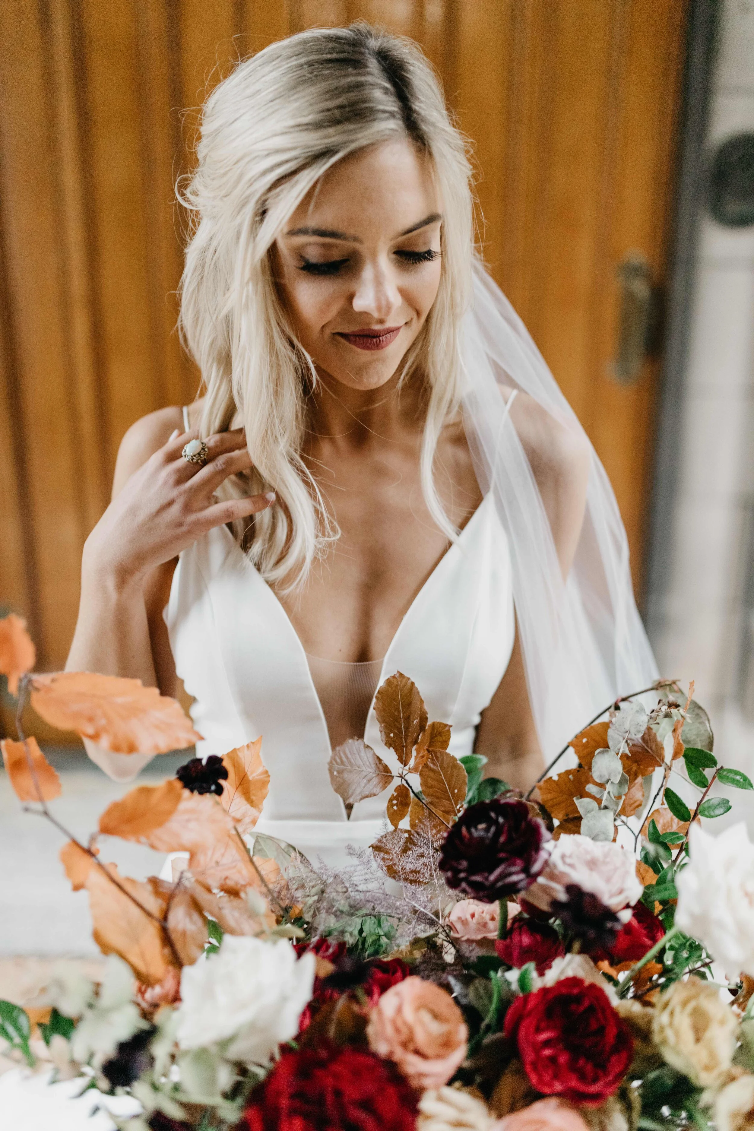 Lush, asymmetrical bridal bouquet with rich fall color palette of deep plum, eggplant, copper, and rusty orange with garden roses, ranunculus, and greenery. Nashville wedding floral designer, Rosemary & Finch, at Clementine.
