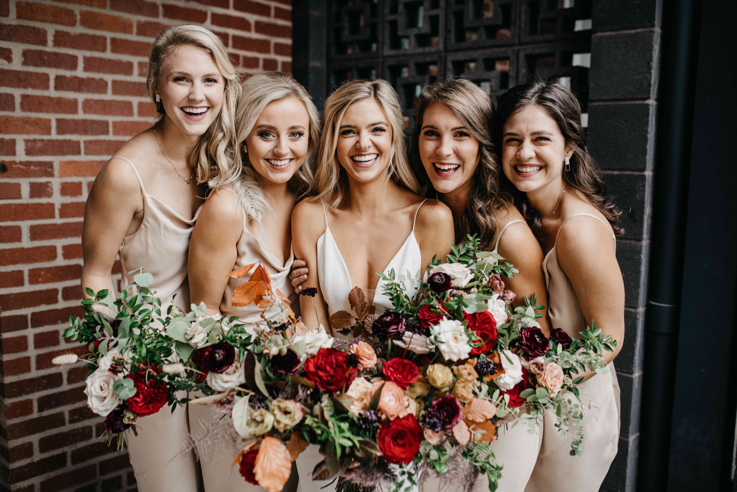 Champagne bridesmaid dresses with vibrant, deep color palette for the bouquets with burgundy garden roses, dusty rose and eggplant ranunculus, copper fall foliage, and airy greenery. Nashville wedding florist, Rosemary & Finch Floral Design.
