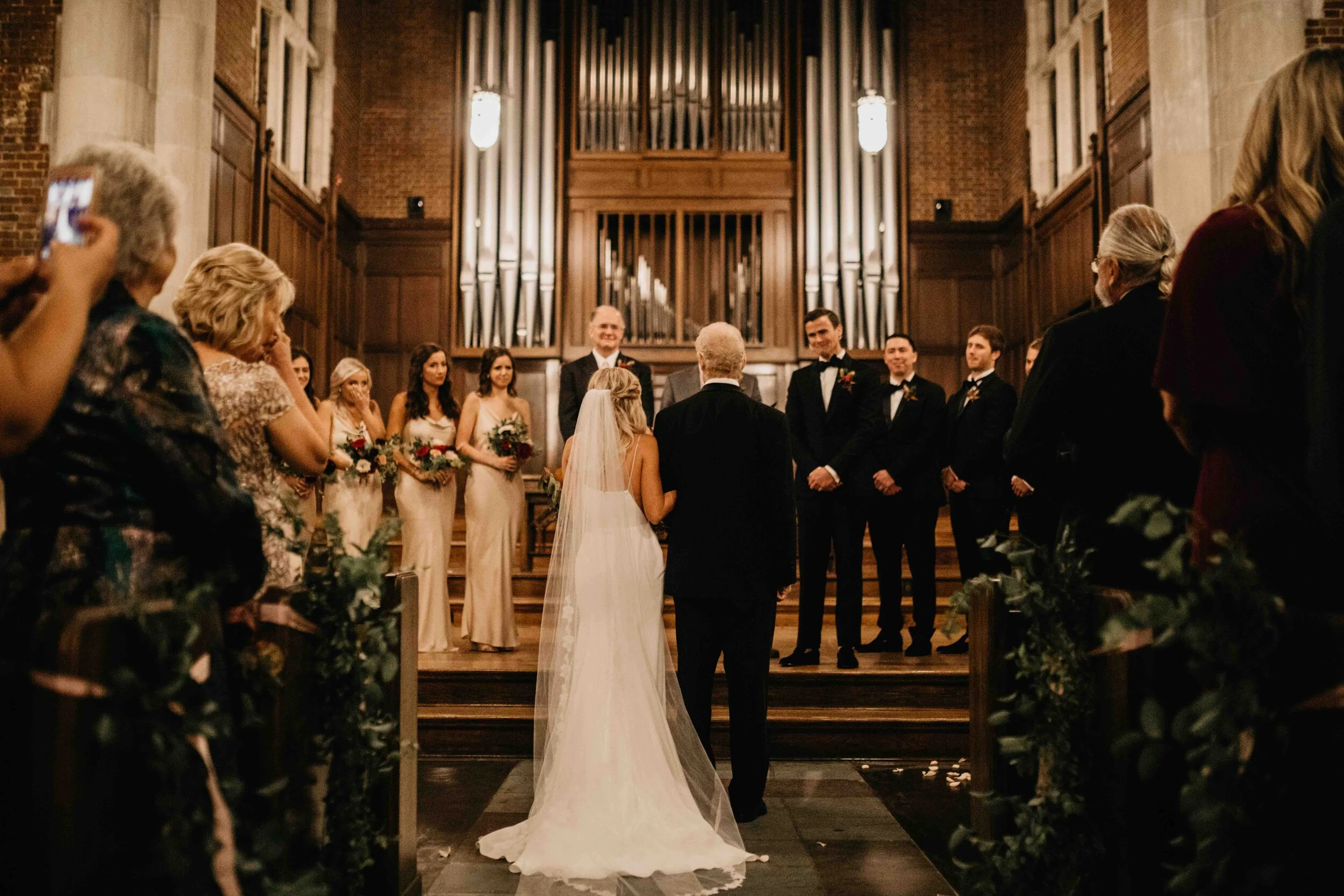 October wedding ceremony in the Wightman Chapel at Scarritt-Bennett. Natural, asymmetrical bride’s bouquet with fall flowers and lush greenery. Nashville luxury wedding florist.