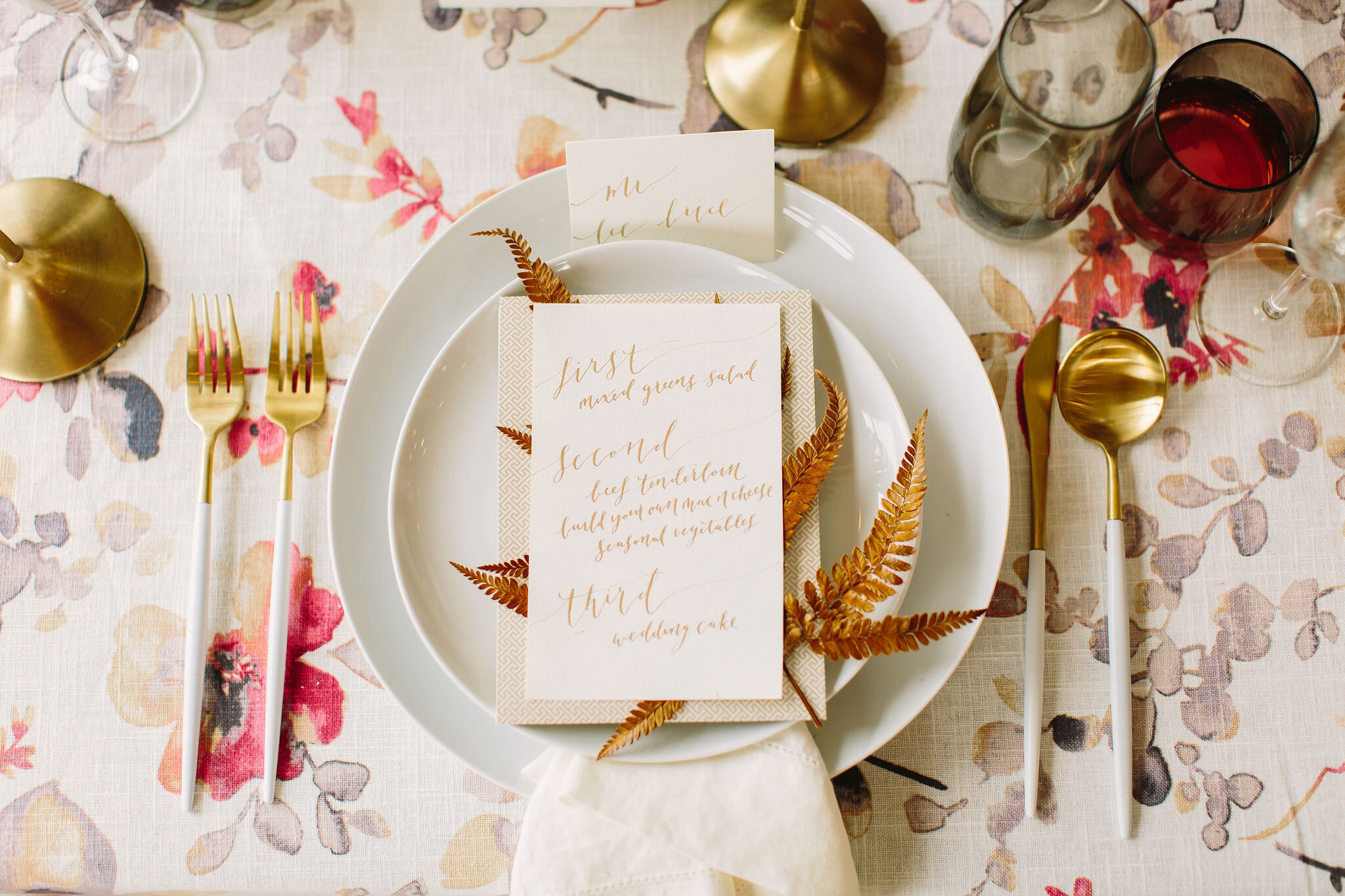 Early summer place setting with golden brown fern accent and floral linen. Nashville wedding florist.