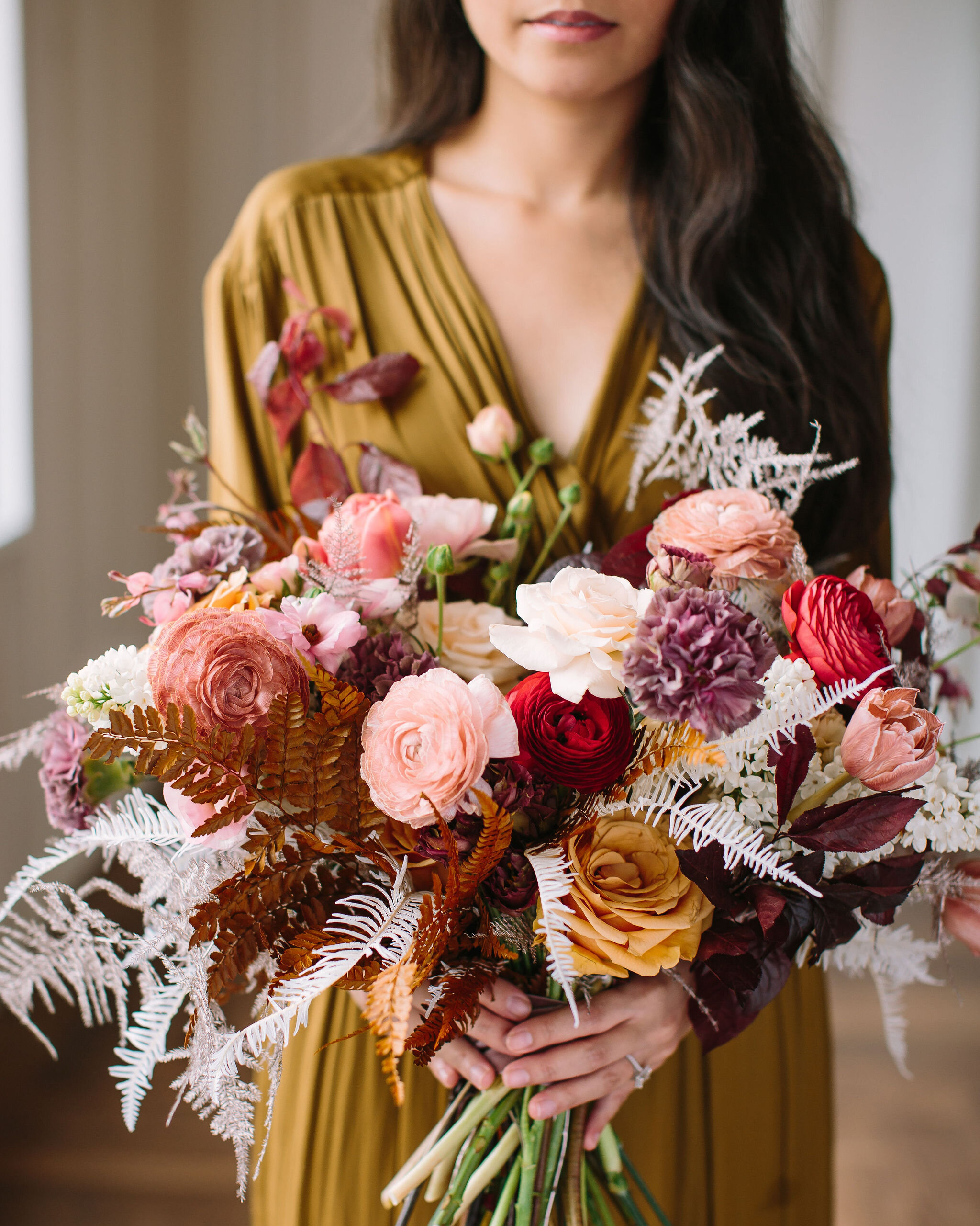 Organic, modern bouquet with dried white ferns, dusty pink ranunculus, golden brown ferns, spirea, bleeding hearts, and other dainty spring flowers. Nashville wedding and event floral design by Rosemary & Finch at 14Tenn.