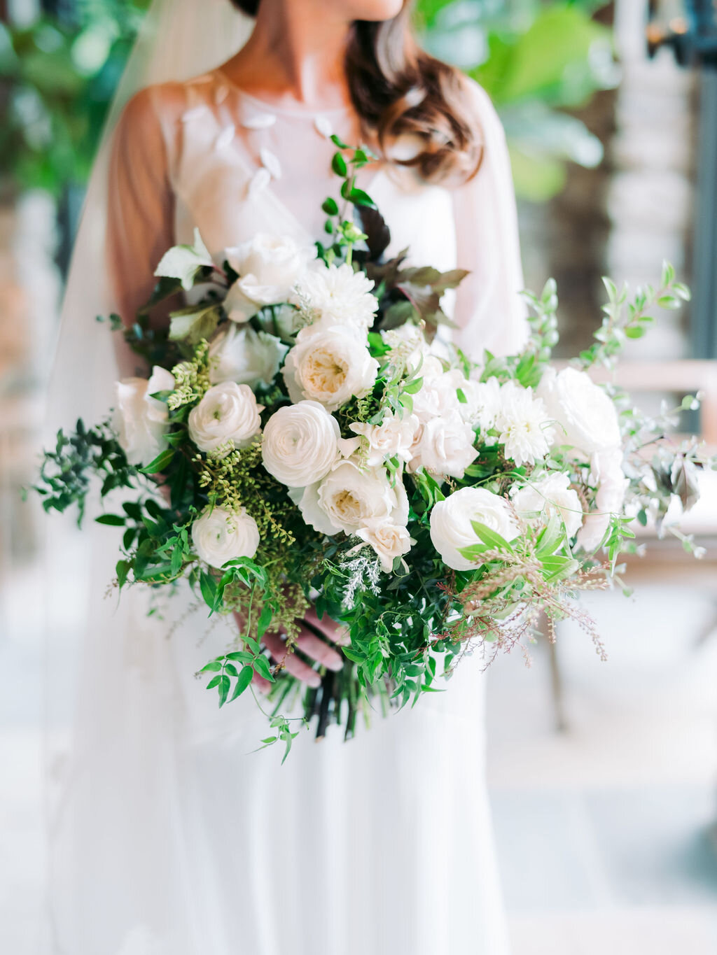 Organic, garden inspired bride’s bouquet with white garden roses, dahlias, and ranunculus with trailing vines and greenery. Nashville wedding floral design.