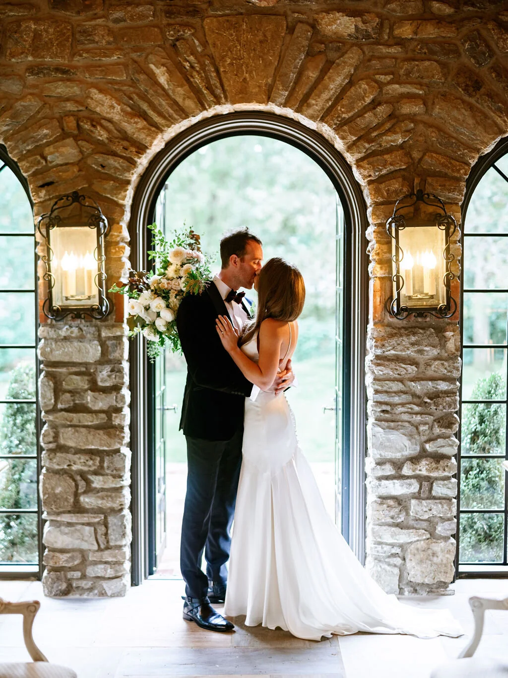 Organic, garden inspired bride’s bouquet with white garden roses, dahlias, and ranunculus with trailing vines and greenery. Nashville wedding floral design.
