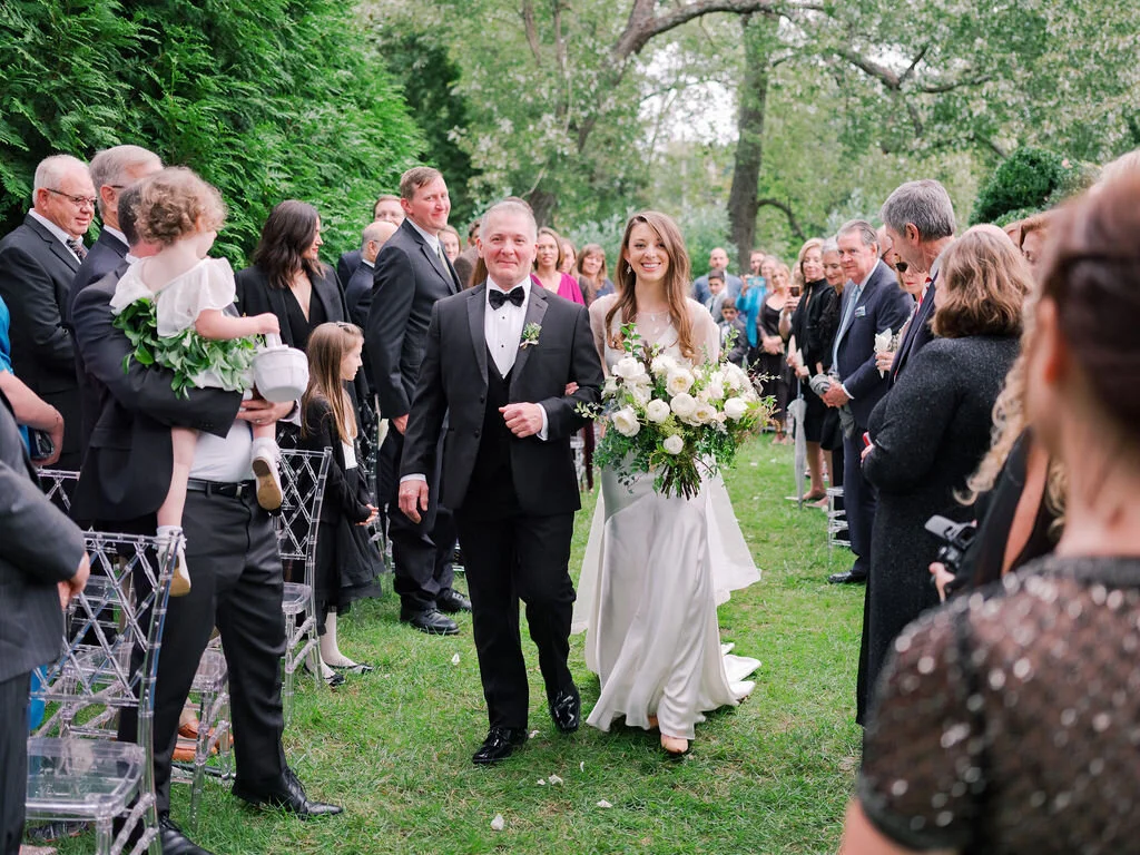 Organic, garden inspired bride’s bouquet with white garden roses, dahlias, and ranunculus with trailing vines and greenery. Nashville wedding floral design.