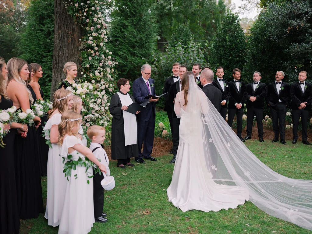 Lush floral installation on an old oak tree with natural vines and greenery with a profusion of white, ivory, and blush garden roses, dahlias, ranunculus, and wildflowers. Belle Meade, Nashville wedding floral design.