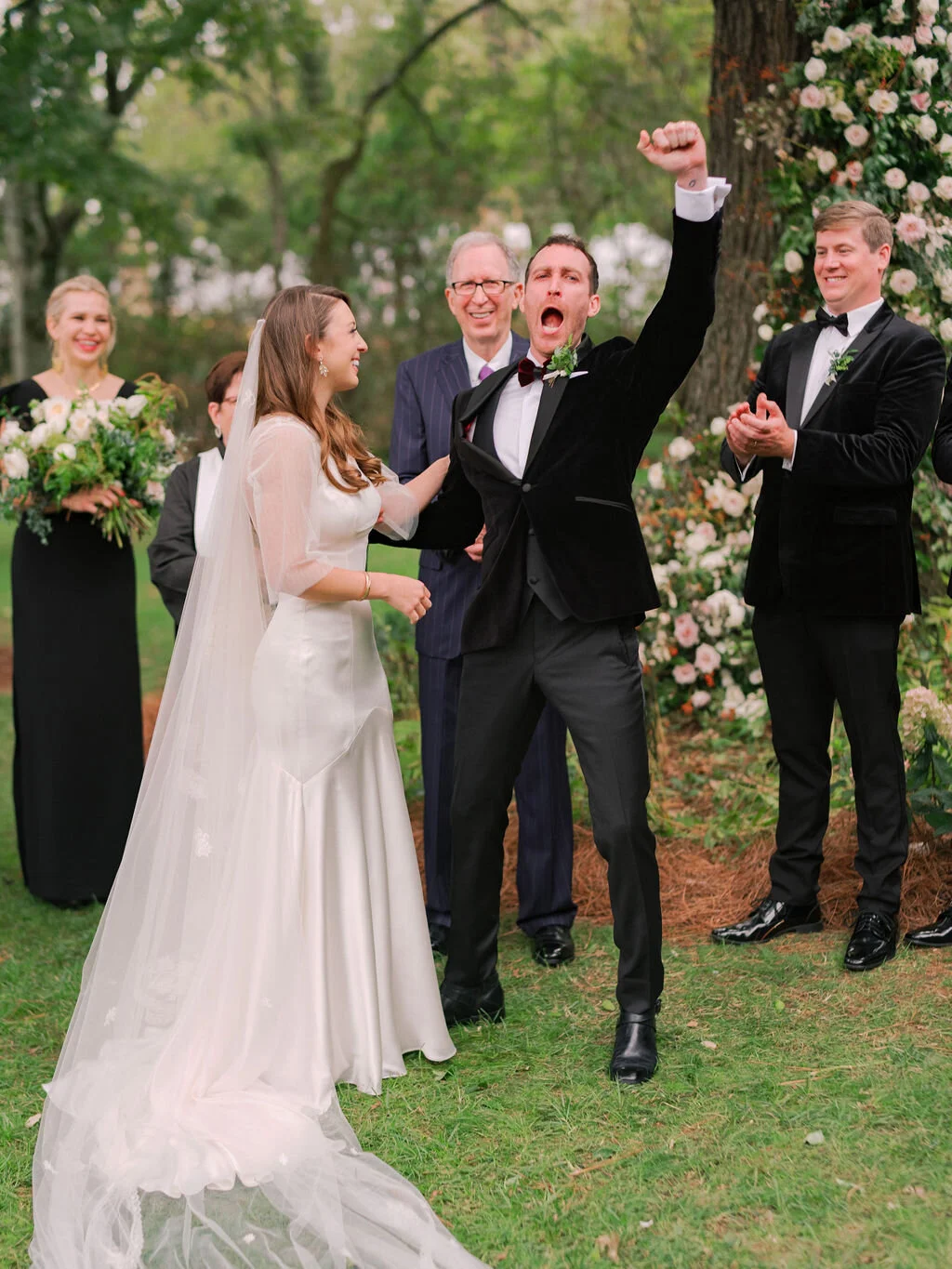 Lush floral installation on an old oak tree with natural vines and greenery with a profusion of white, ivory, and blush garden roses, dahlias, ranunculus, and wildflowers. Belle Meade, Nashville wedding floral design.