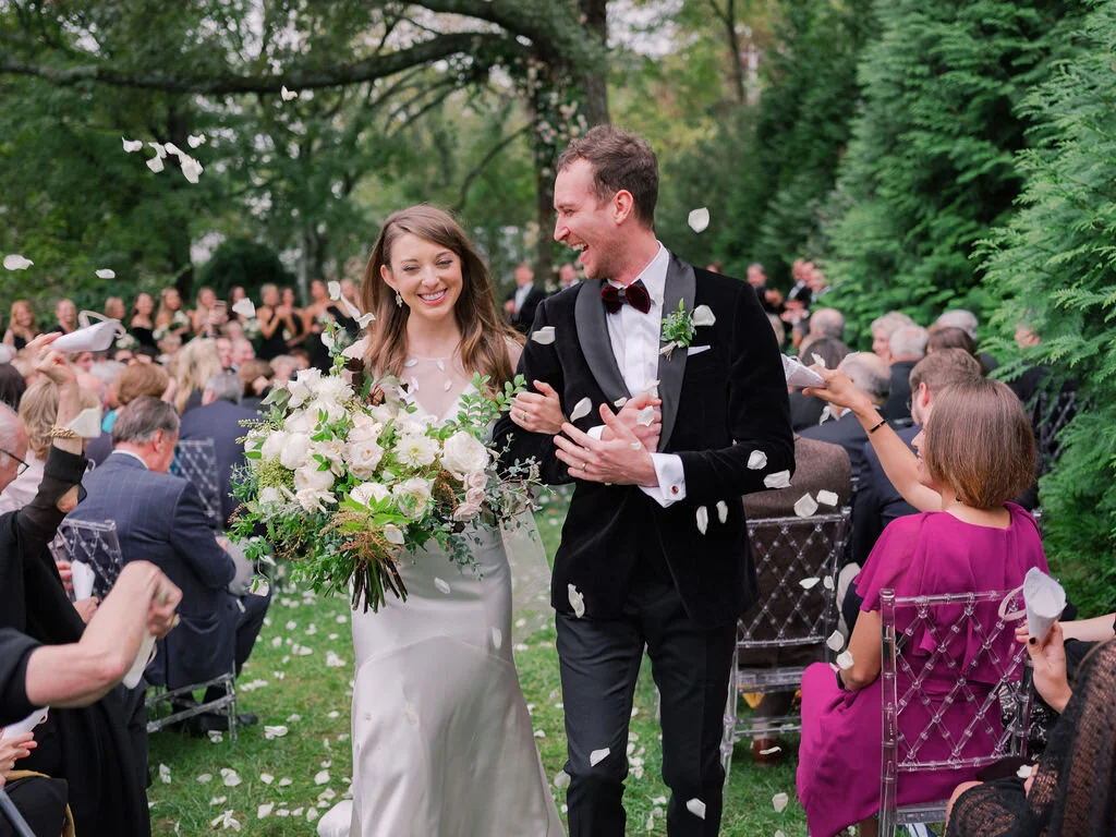 Lush floral installation on an old oak tree with natural vines and greenery with a profusion of white, ivory, and blush garden roses, dahlias, ranunculus, and wildflowers. Belle Meade, Nashville wedding floral design.