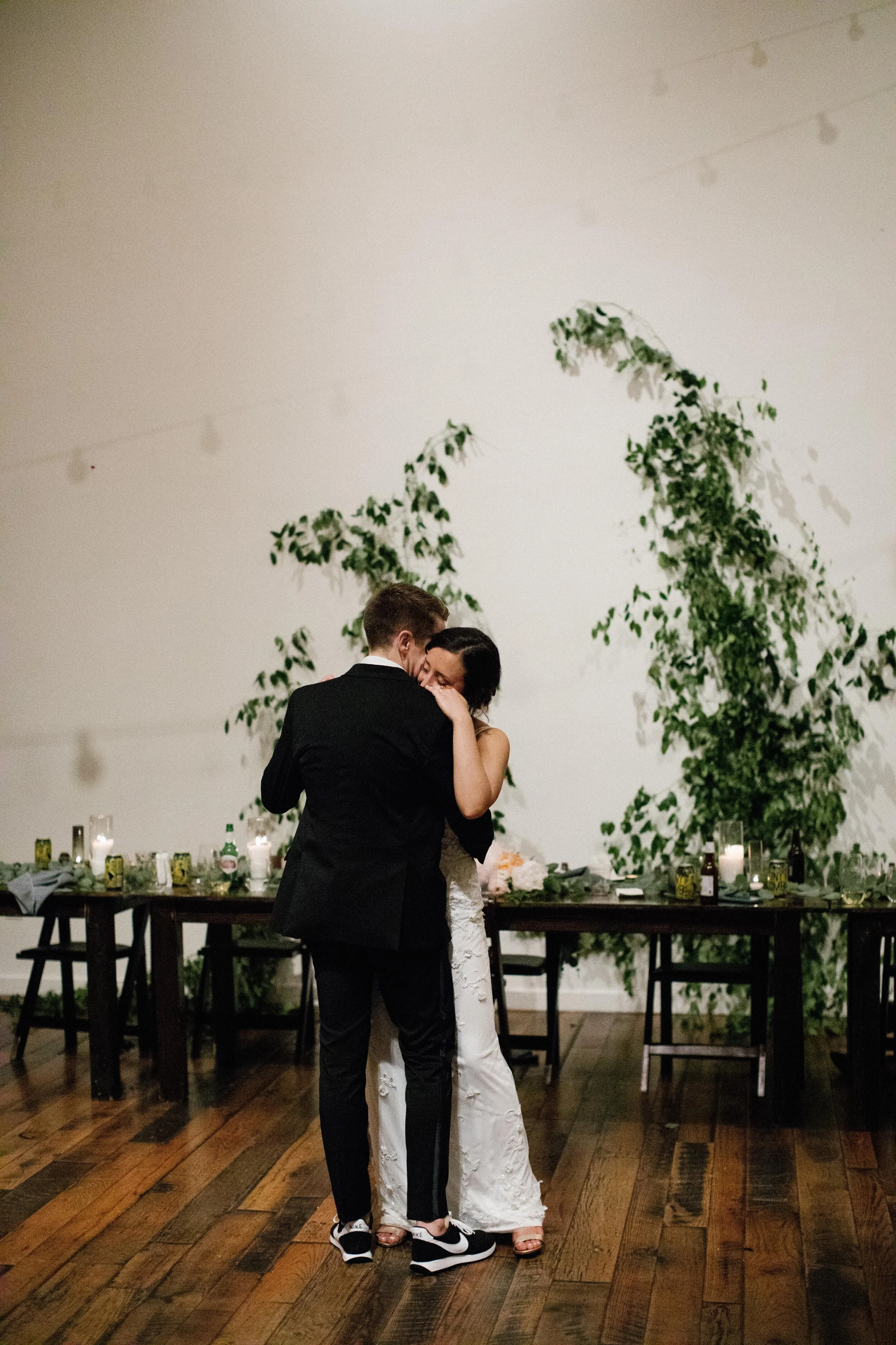 Vine-like greenery installation - creating an arch on the white wall at the Cordelle as the wedding ceremony backdrop. Nashville wedding floral design.