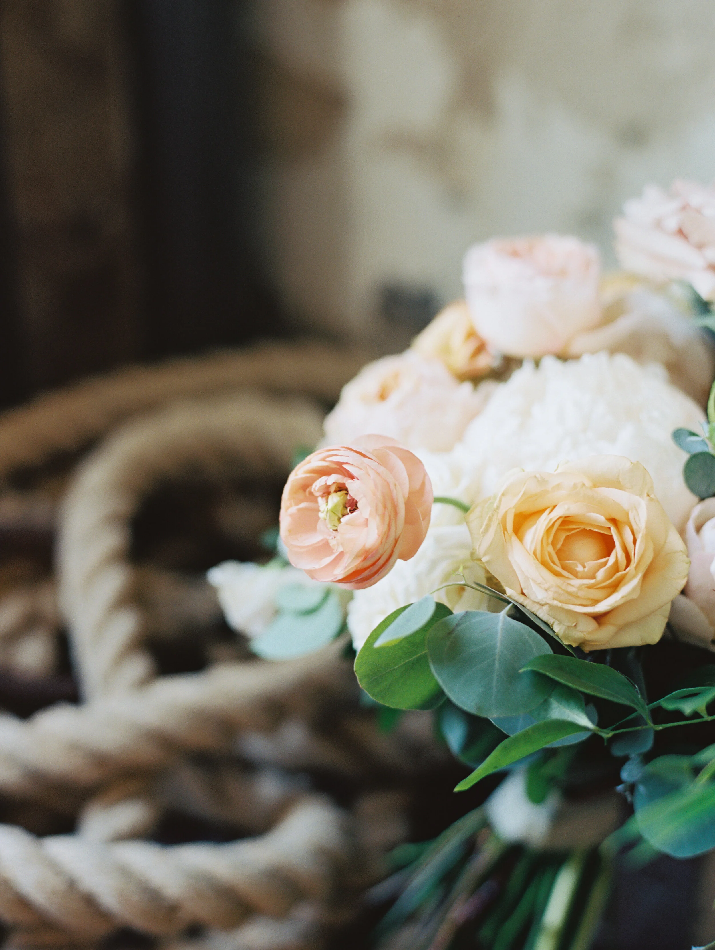 Bridal bouquet with peach ranunculus, cream peonies, blush and golden yellow garden roses, and natural, untamed greenery. June wedding at the Cordelle. Nashville Wedding Florist.