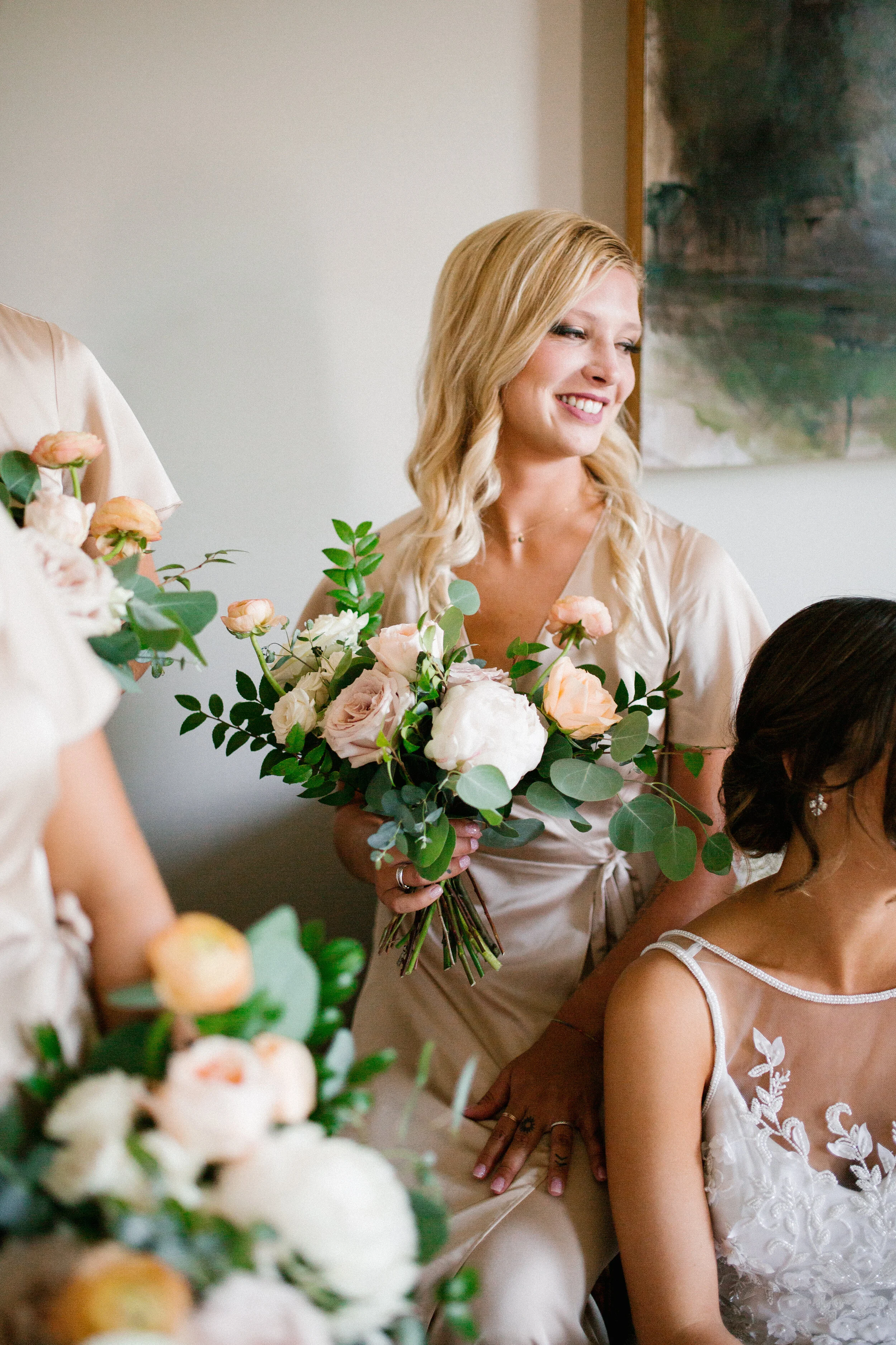 Lush, garden-inspired bouquets with peach, white, and dusty rose flowers and natural greenery. Champagne silk bridesmaid dresses. Nashville wedding florist.