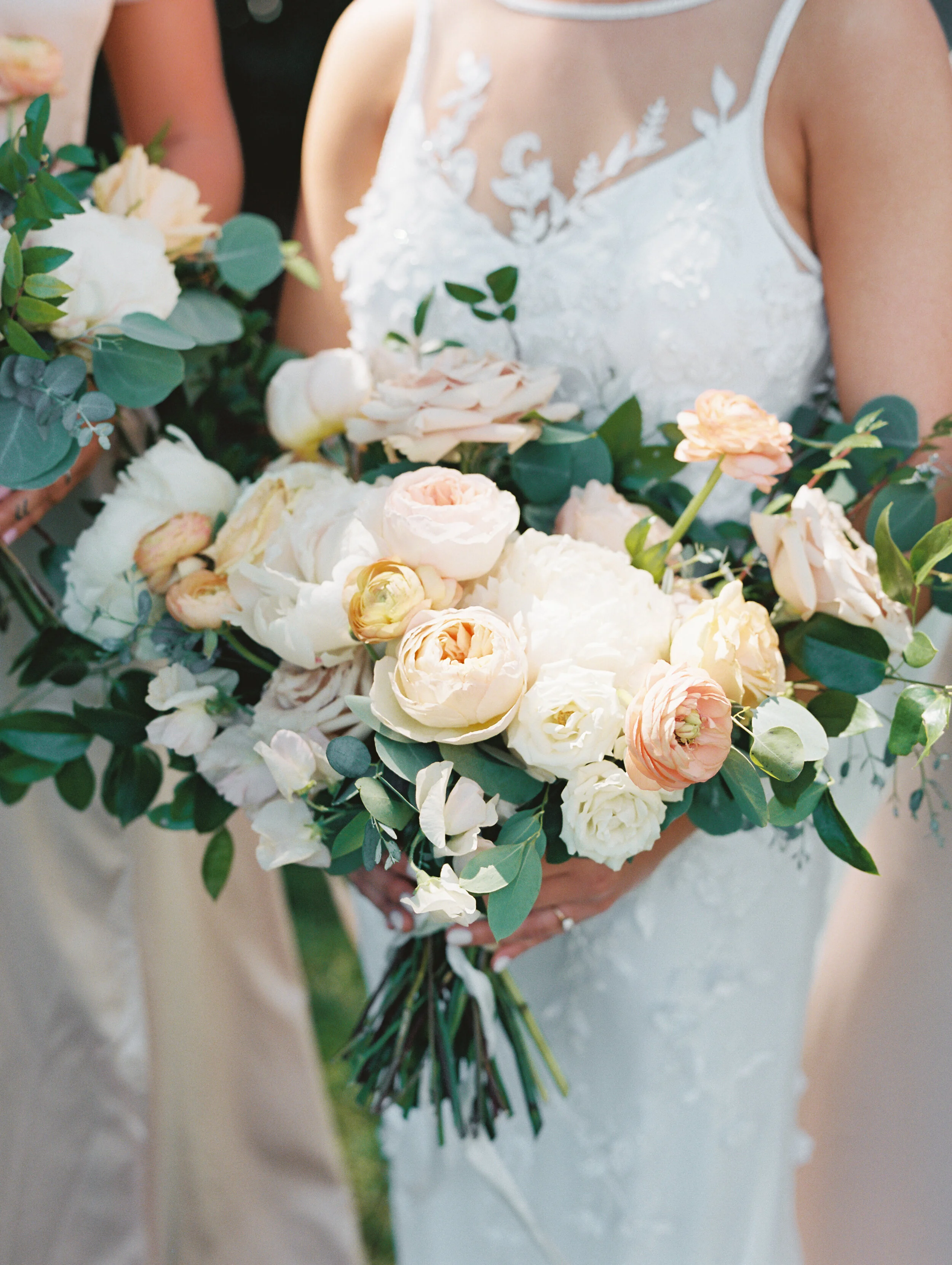 Lush, garden-inspired bouquets with peach, white, and dusty rose flowers and natural greenery. Champagne silk bridesmaid dresses. Nashville wedding florist.