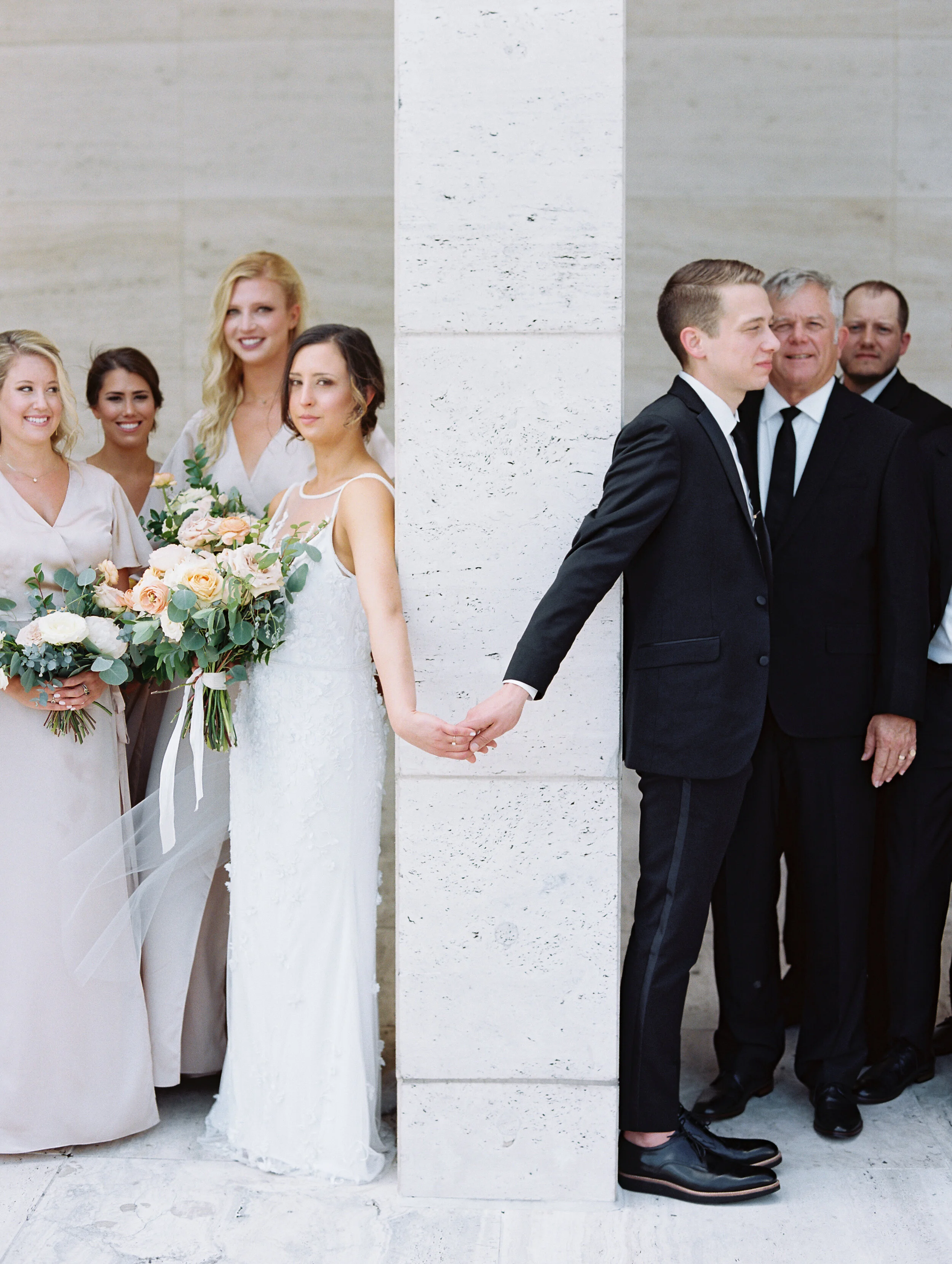 Bridal party portraits at Tennessee Tower in downtown Nashville. Asymmterical, whimsical bouquets with garden roses, ranunculus, and greenery.