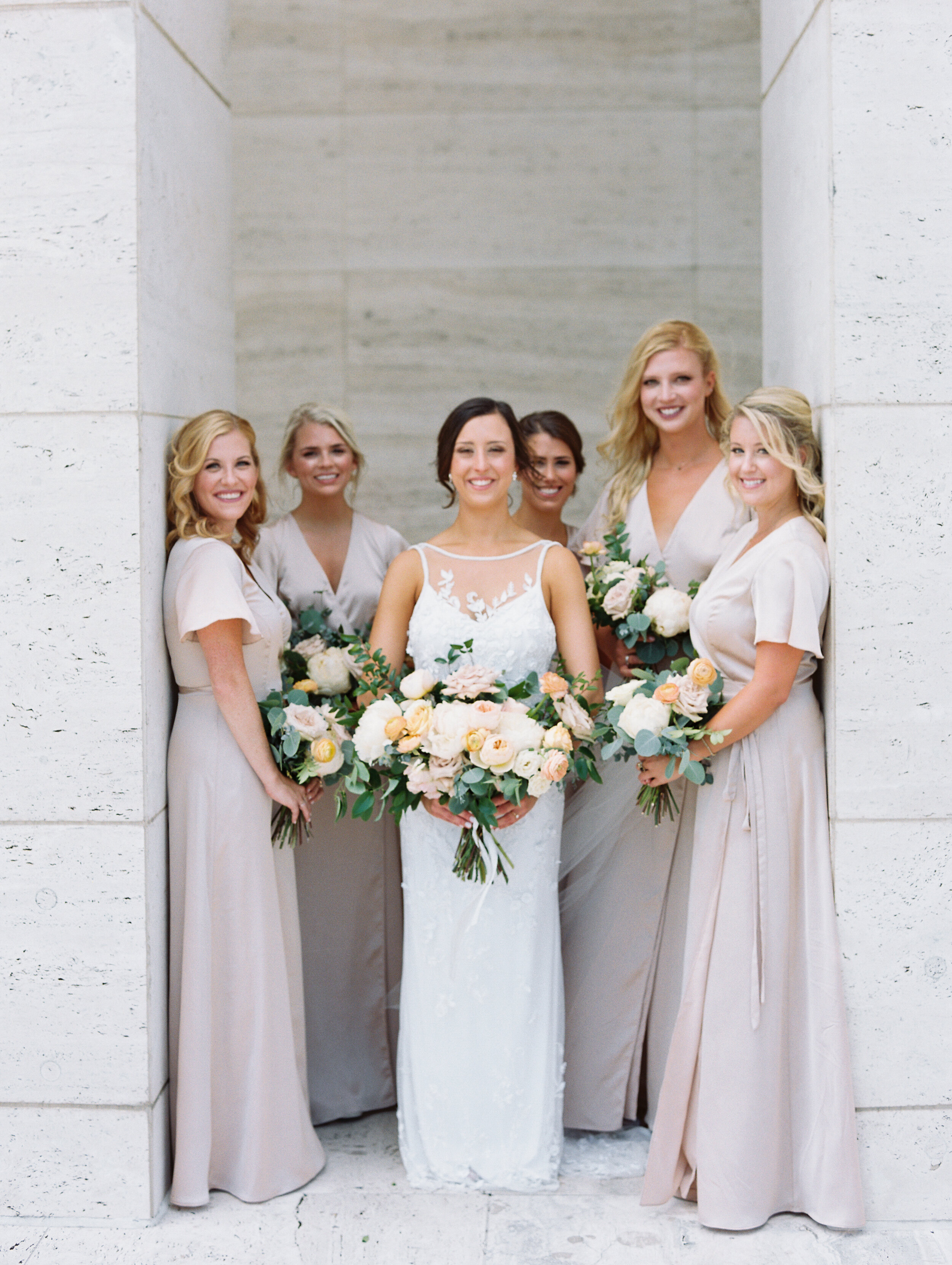 Bridal party portraits at Tennessee Tower in downtown Nashville. Asymmterical, whimsical bouquets with garden roses, ranunculus, and greenery.